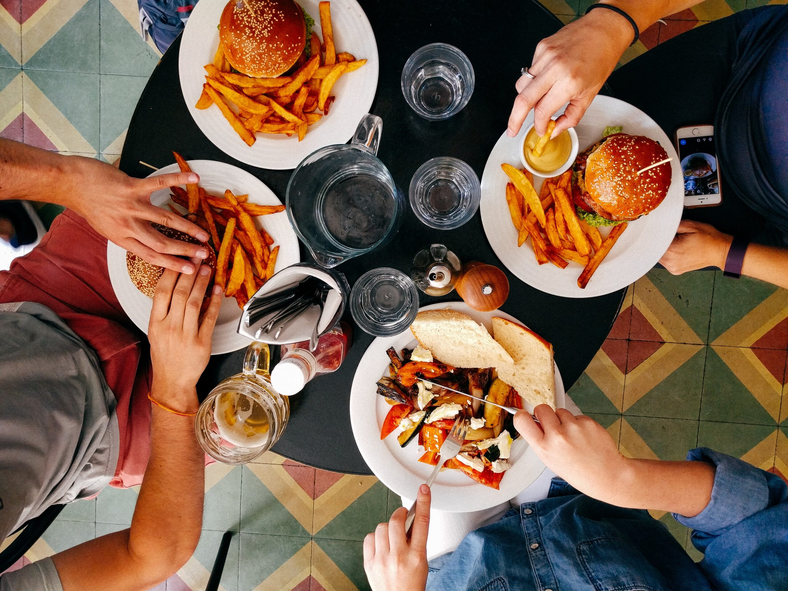 食卓を囲む手元。食事をするだけでも、摂取カロリーの約10%はその消化・吸収のために消費される