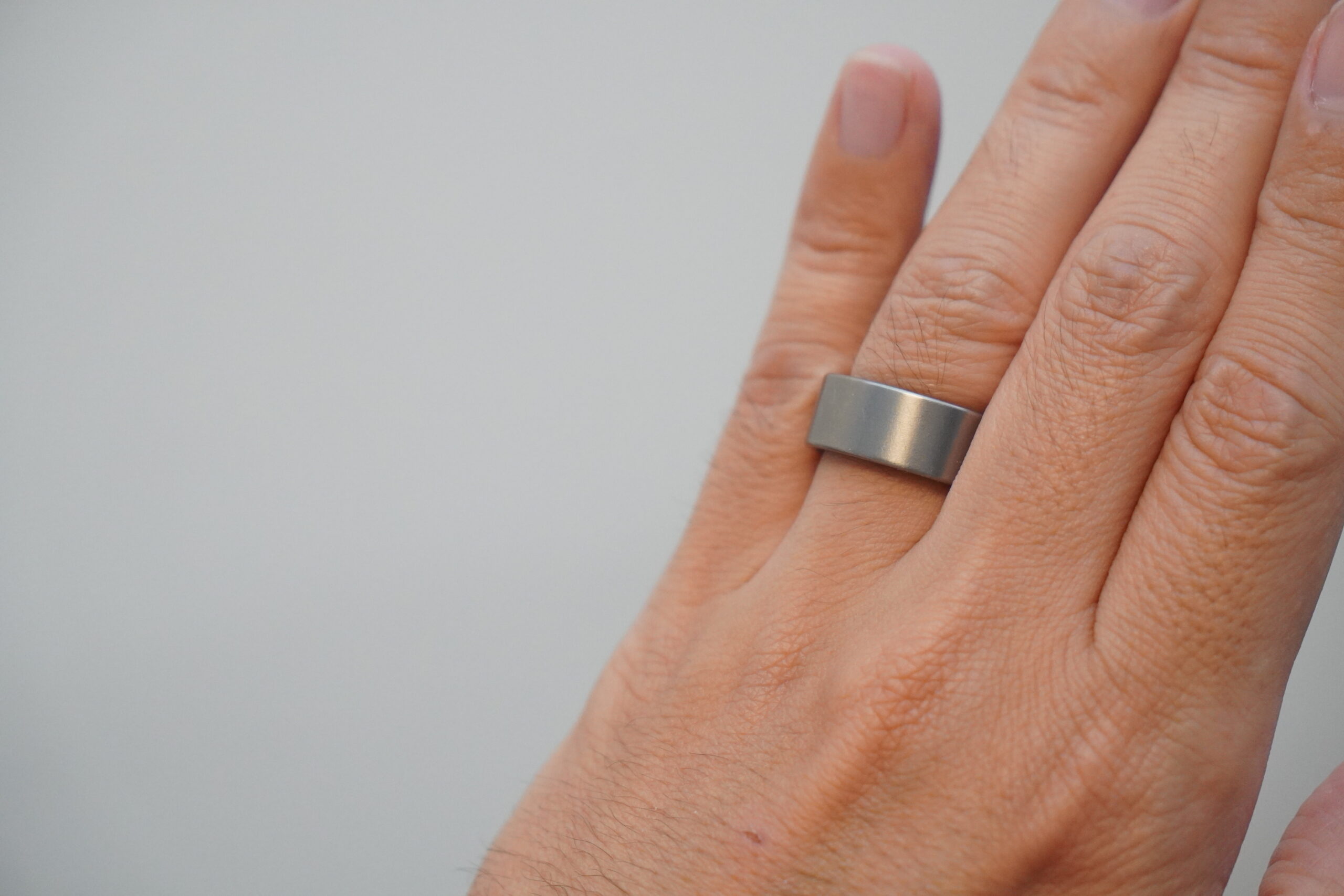 Ultrahuman Ring AIRを指にはめた状態。幅の広いリングが人差し指に収まっている。