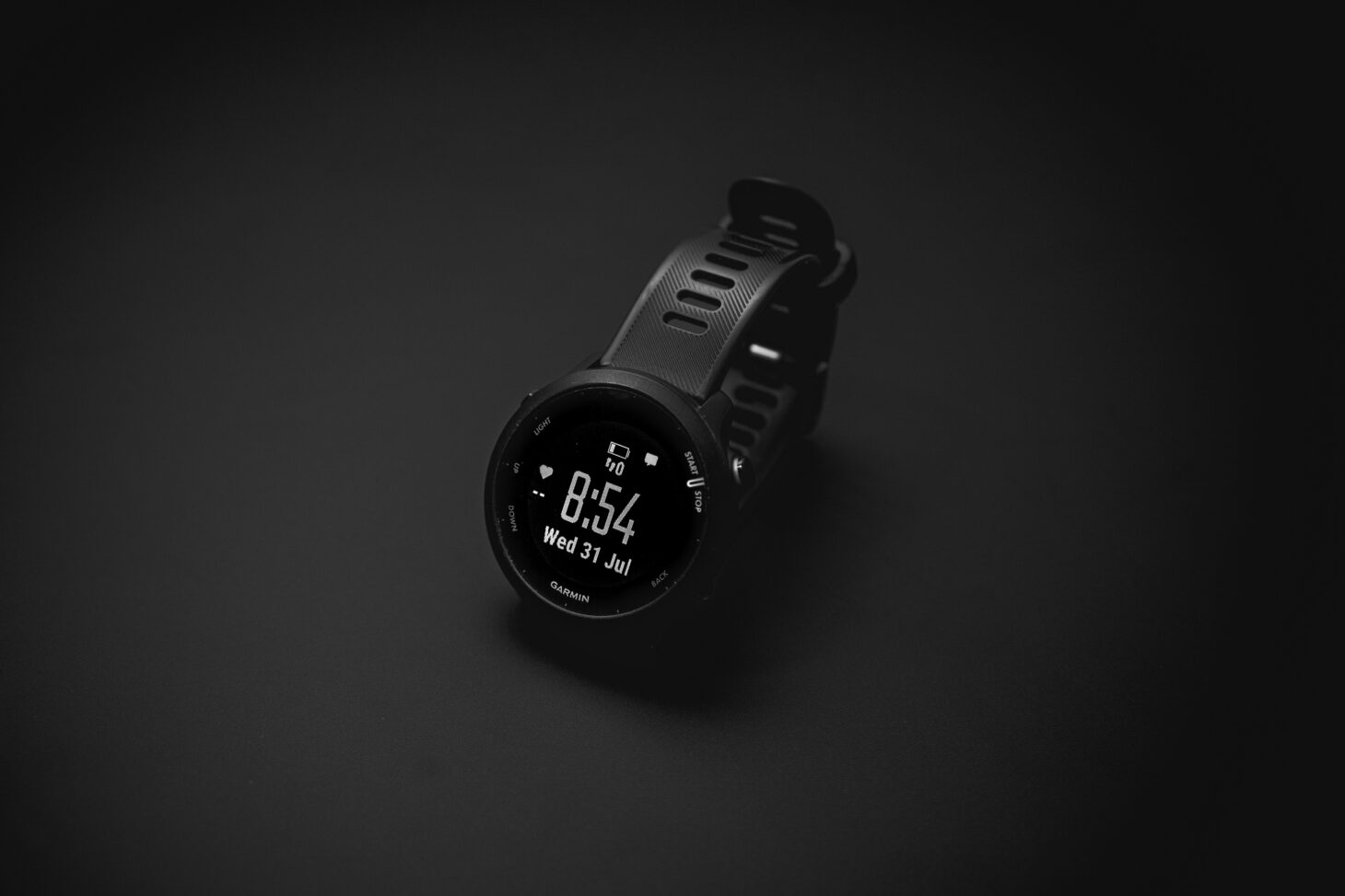 暗い背景に置かれたGarminのGPSランニングウォッチ
