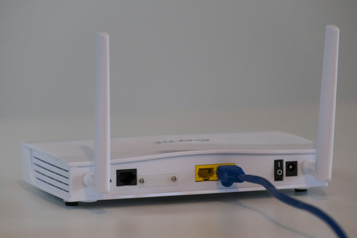 LANケーブルを接続した白いWi-Fiルーターの背面端子