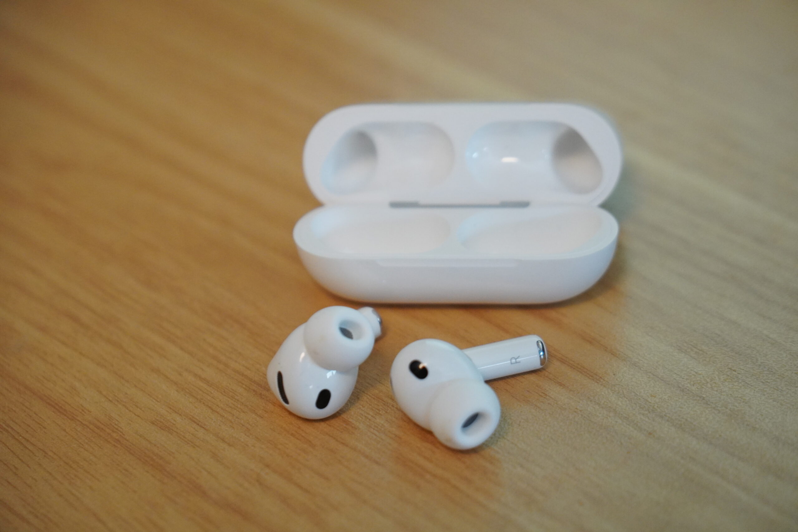 AirPods Pro 3の本体と充電ケースを机に置いたところ