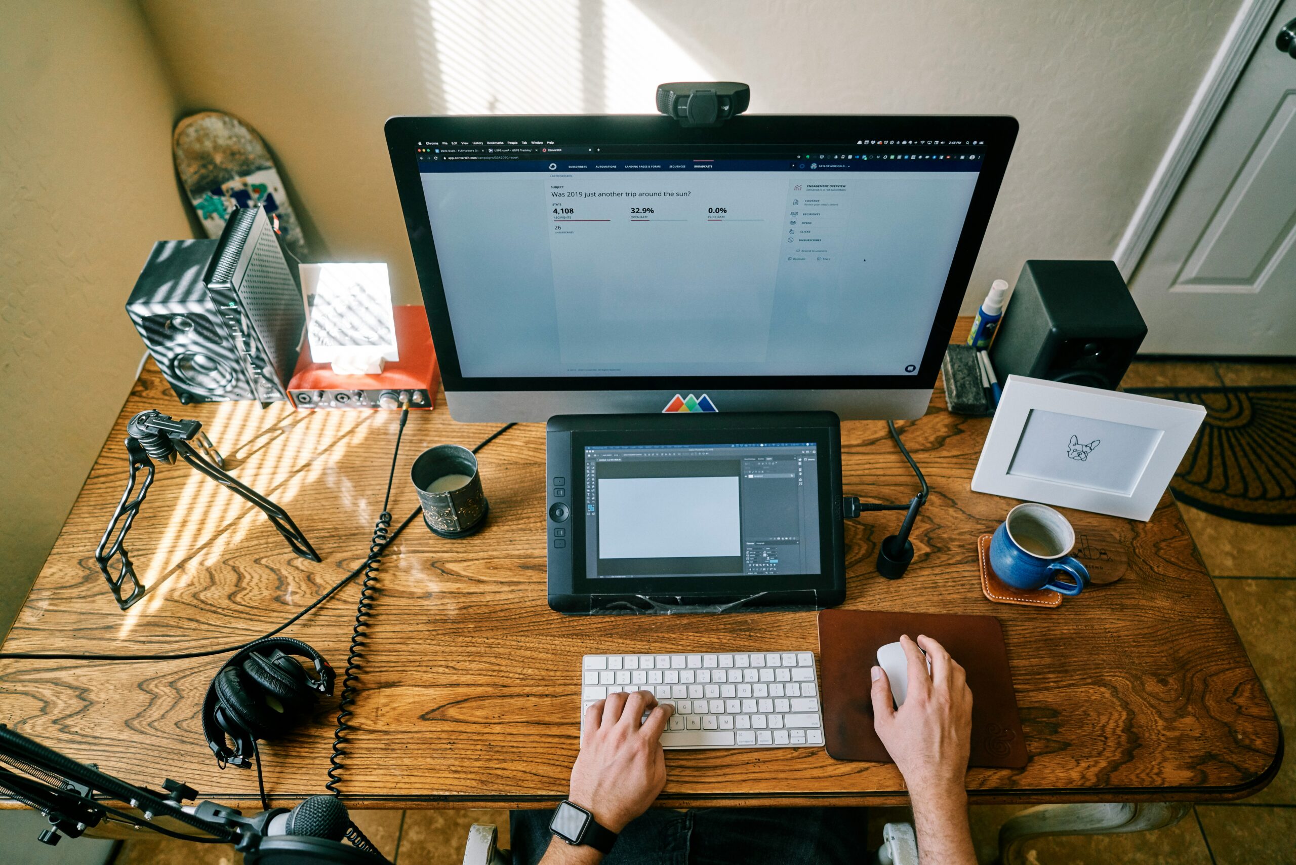 iMacと液晶タブレットを置いた木製デスクで作業する手元(イメージ画像)