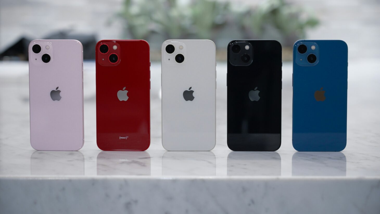 大理石調の台に並べたiPhone 13の5色の背面。カメラは斜めに配置された2眼