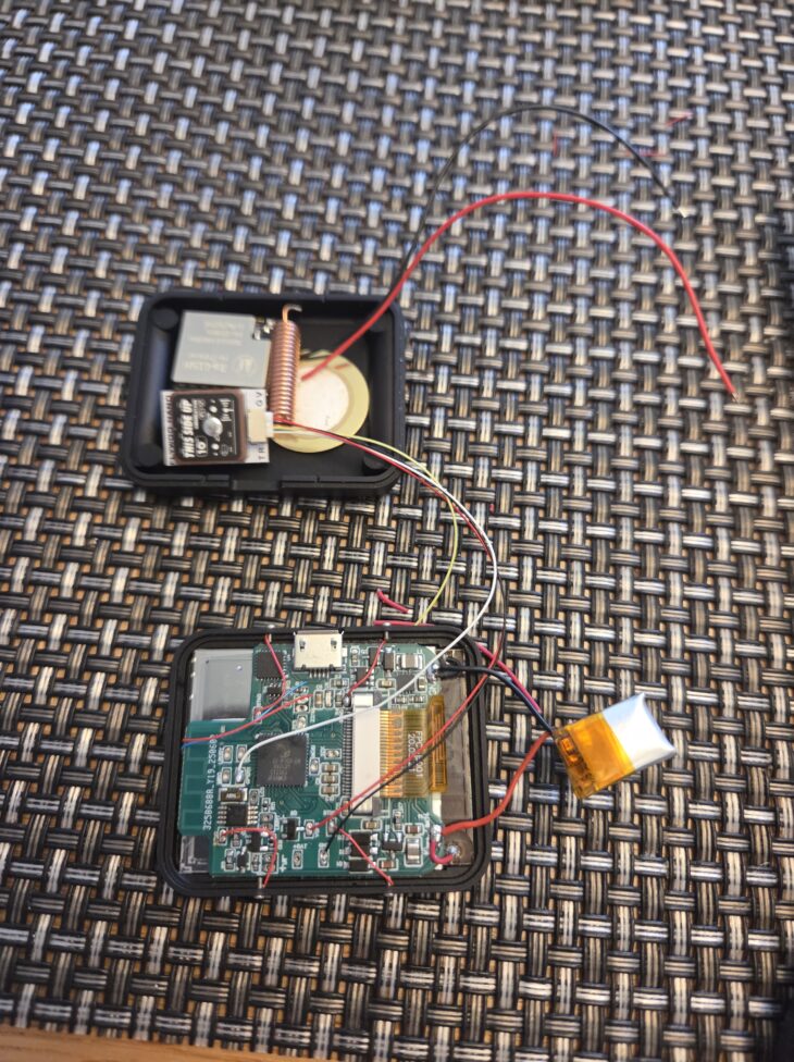 LightInk スマートウォッチの内部を分解した様子。GPSモジュール、コイルアンテナ、リチウムポリマー電池、基板などが見える。
