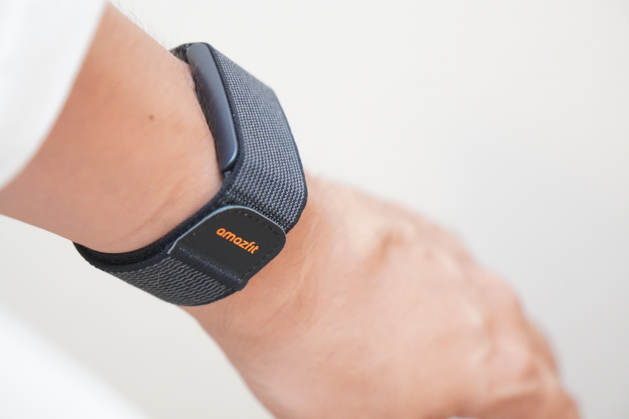 手首に装着したAmazfit Helio Strap。織りのストラップに小さな本体が付いていて画面はない