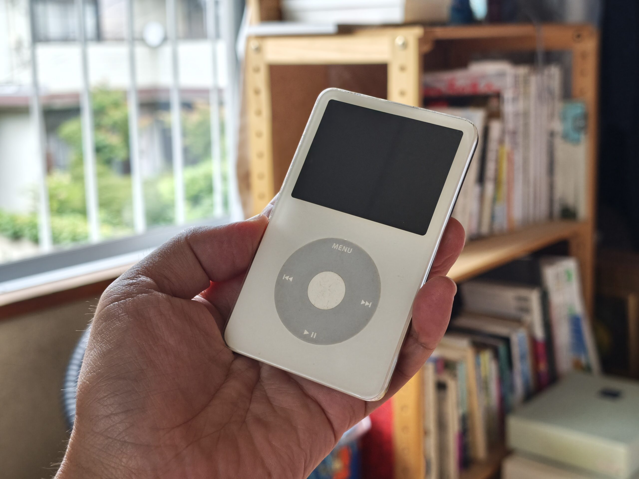 Xiaomi 17T Proで撮影した作例。妻の実家にあったiPod classicを手持ちで撮影、白いボディの質感やガラス面の反射、奥の本棚と窓の光のボケまで描写