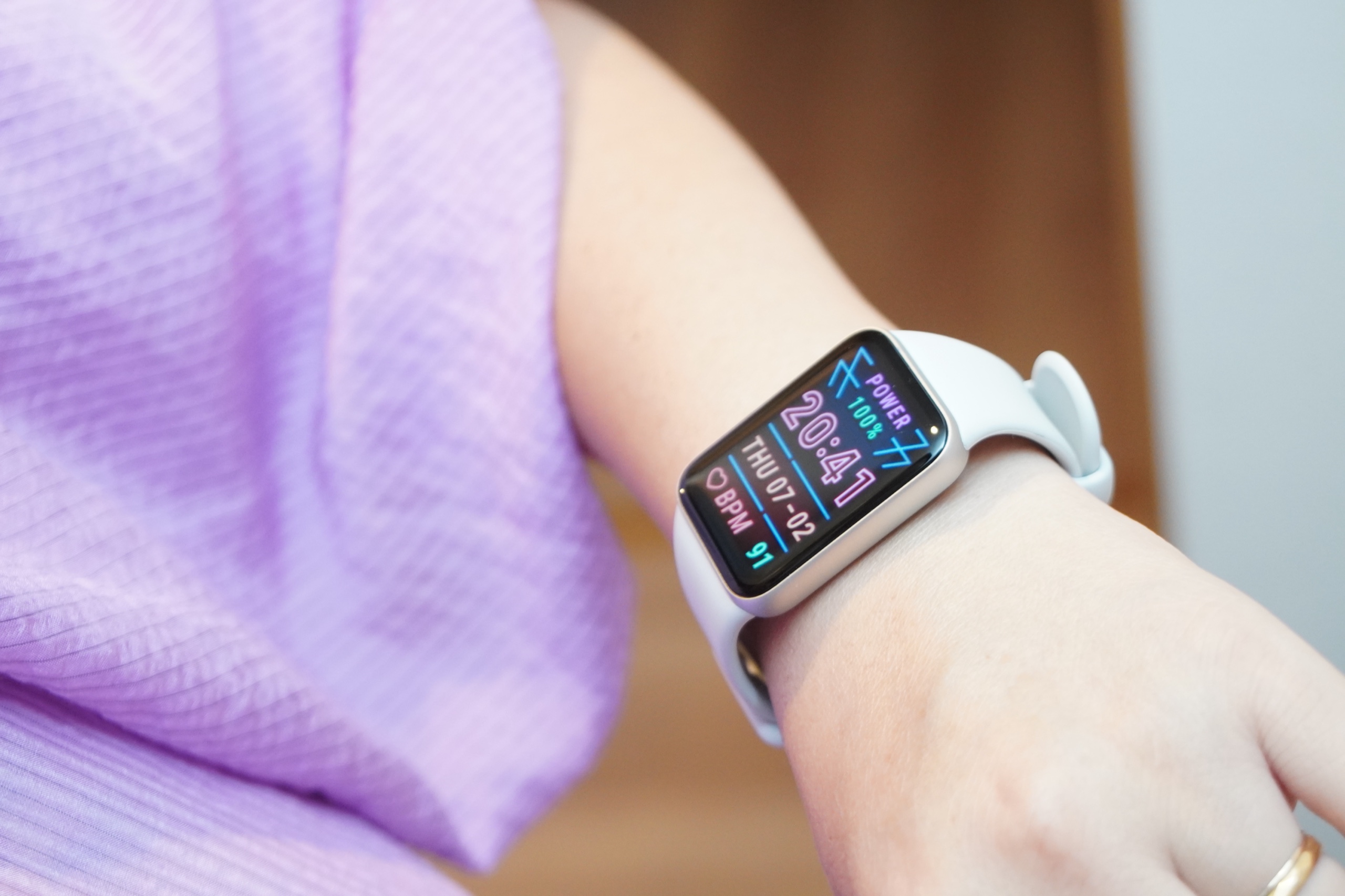 シルバーの Xiaomi Smart Band 10 Pro を女性の手首に着けた様子。横幅の広い大きな画面