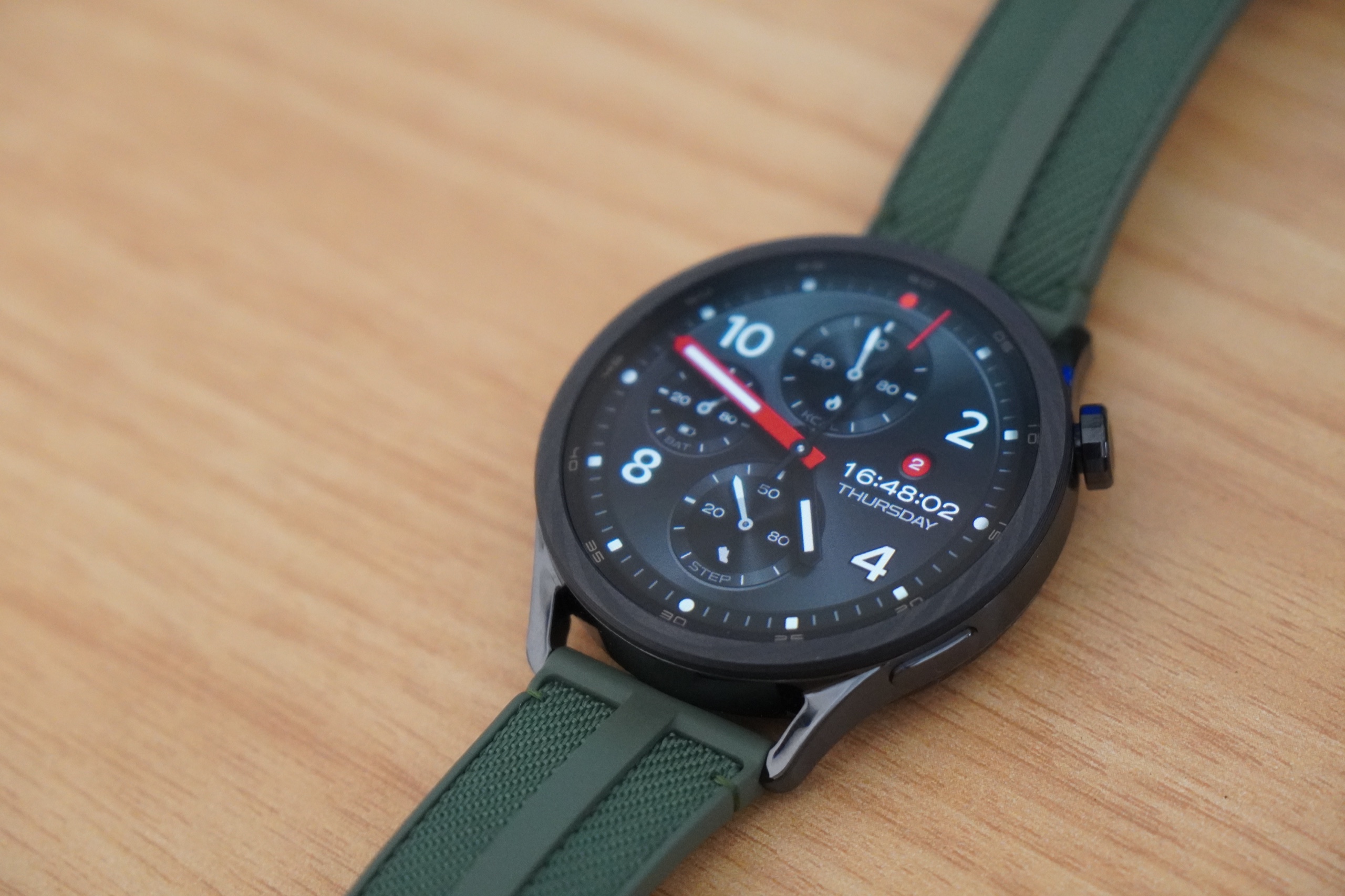 机の上に置かれたXiaomi Watch S5 46mm。グリーンのストラップにブラックのケースを組み合わせたモデル