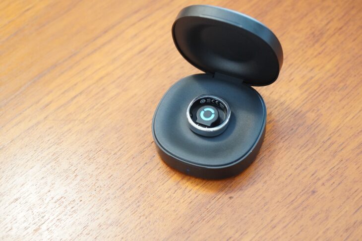 RingConn Gen 3 の充電ケースを開け、中央にリングをセットしたところ。RingConnのロゴが水色に光り、充電中であることを示している