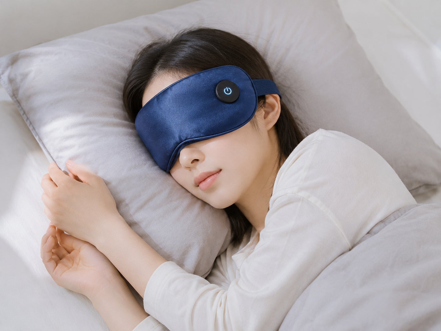 AAJWの充電式ホットアイマスク(ネイビー)を装着して眠る女性