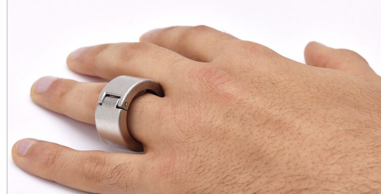 指に装着したスマートリング「CHARM」の実機。金属筐体のリング型デバイスで、汗から血糖など複数の生化学指標を連続測定する