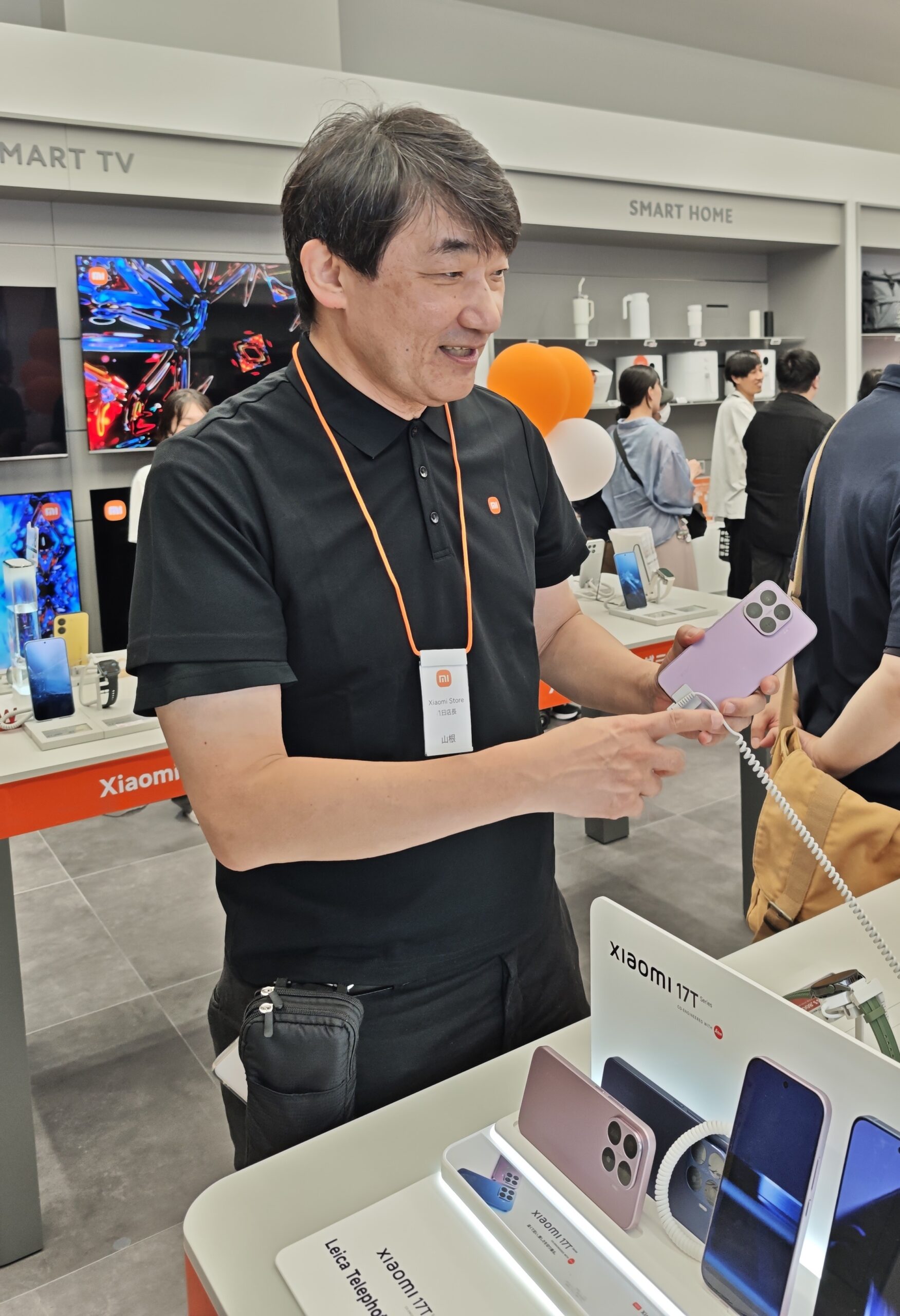 1日店長を務めた携帯電話研究家の山根康宏氏が店内でXiaomiのスマートフォンを紹介する様子