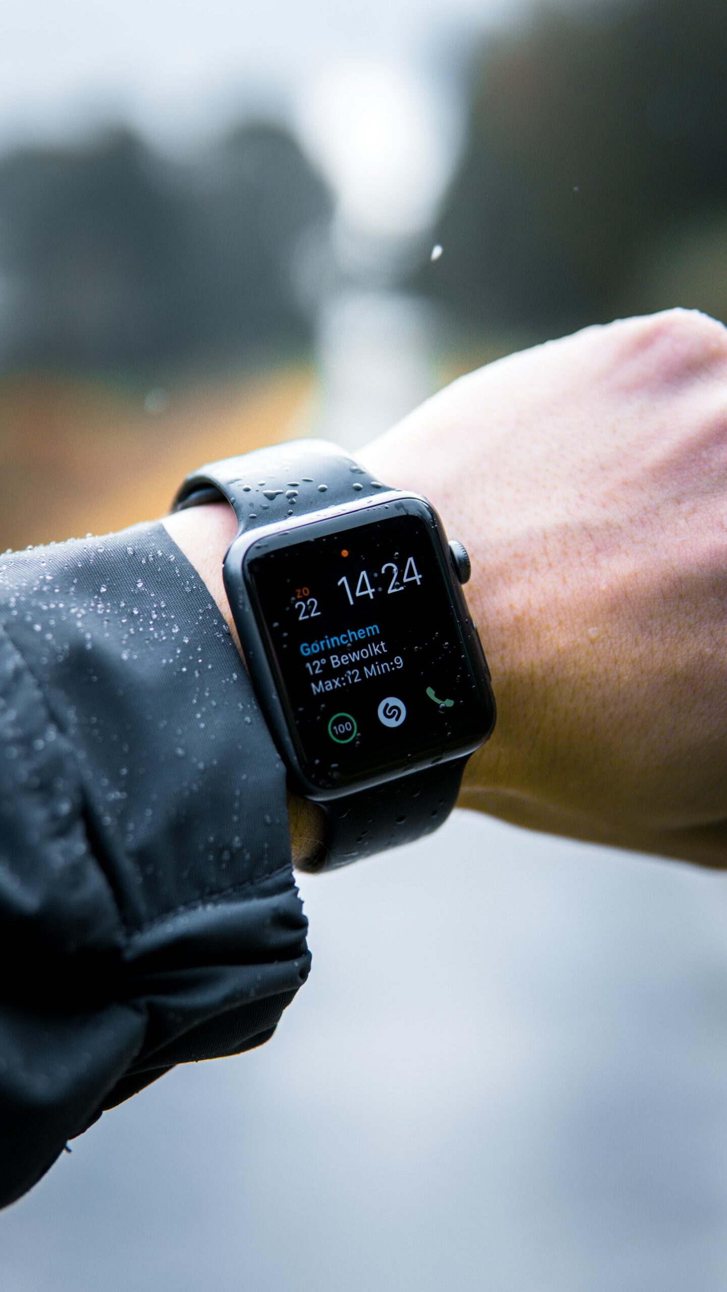 雨の日に手首に着けたApple Watchの画面を確認している様子