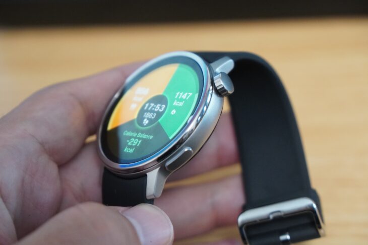 シャープ「からだメイト Watch」を手に持って斜めから見たところ。ステンレスケースとマットな質感のシリコンバンド
