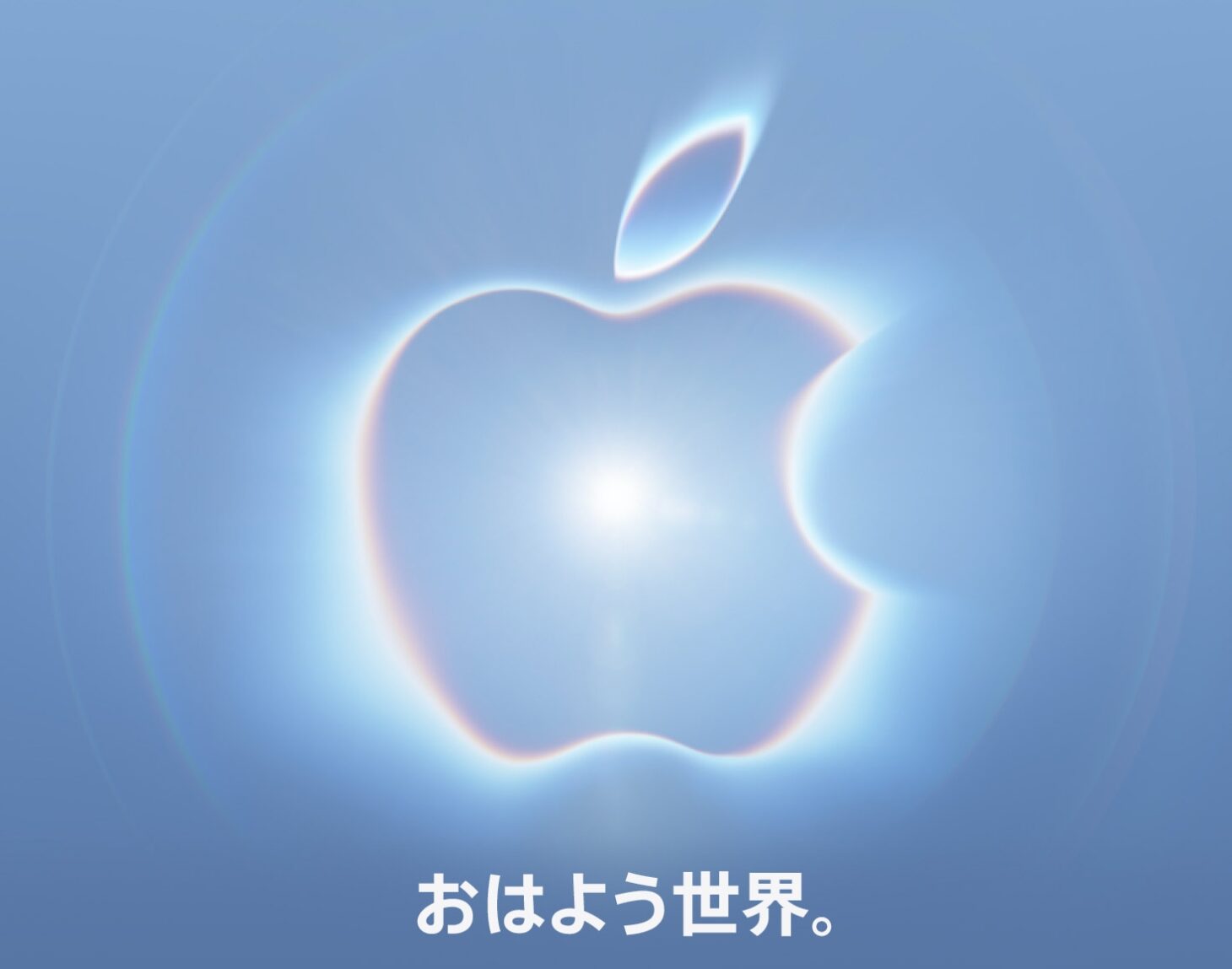 Appleのスペシャルイベント招待状。青いグラデーションの背景に光を放つAppleロゴが浮かび、下部に日本語のタグライン「おはよう世界。」が置かれている