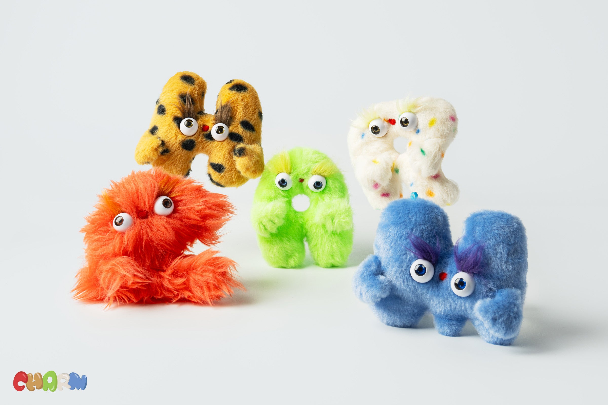 アルファベットの各文字を異なるデザインと素材で表現したぬいぐるみチャーム。