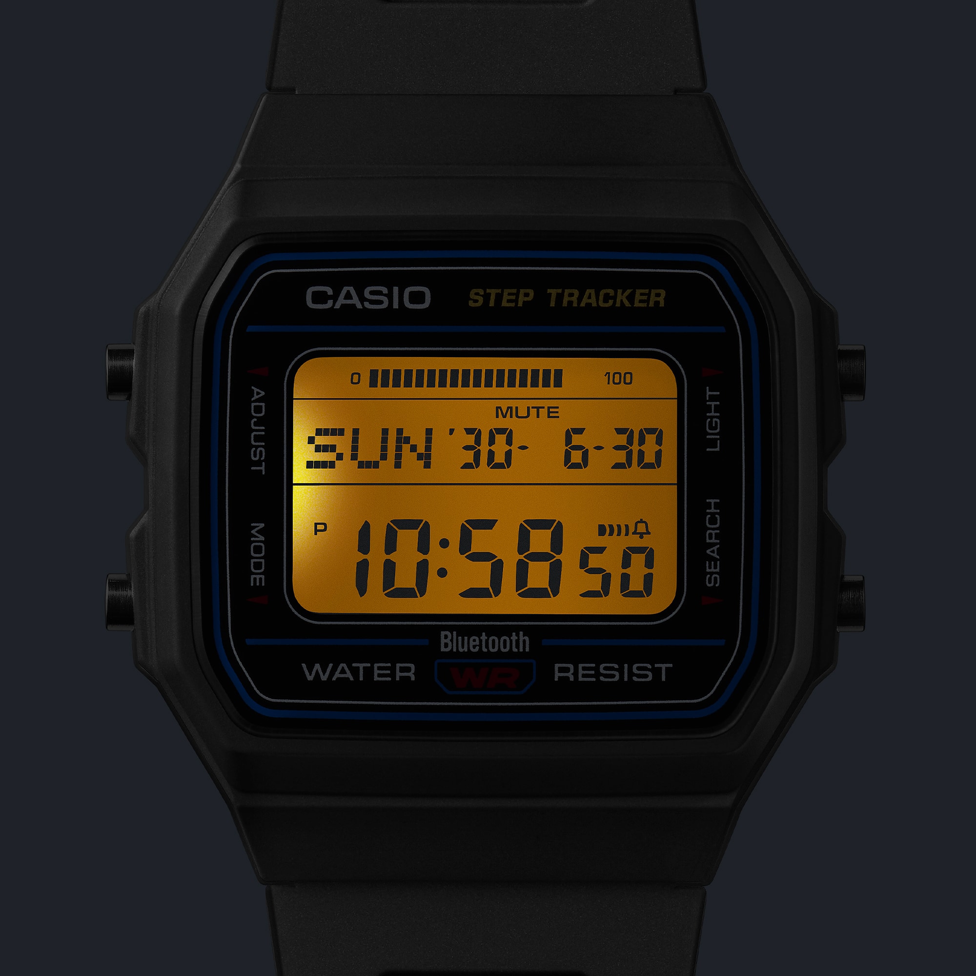 暗所でLEDバックライトを点灯させたCASIO F-B100W-1AJF。液晶全体がアンバー色に照らされ時刻が読み取れる