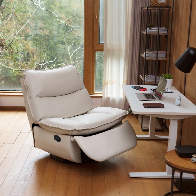 FlexiSpot Lotus Proのライトグレーの電動リクライニングソファ。フットレストを上げた状態で昇降デスクの横に置かれている