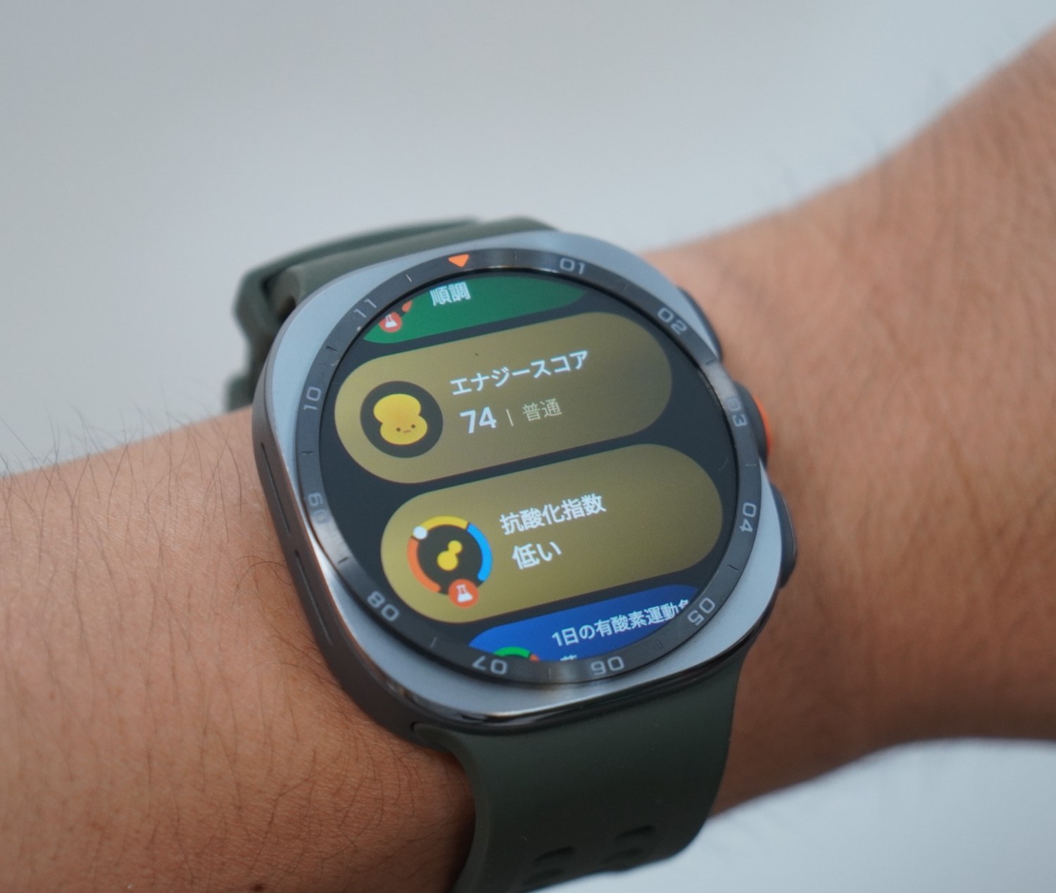 Galaxy Watch Ultra2のホーム画面。エナジースコア74「普通」と、その下に抗酸化指数「低い」のカードが並んでいる。