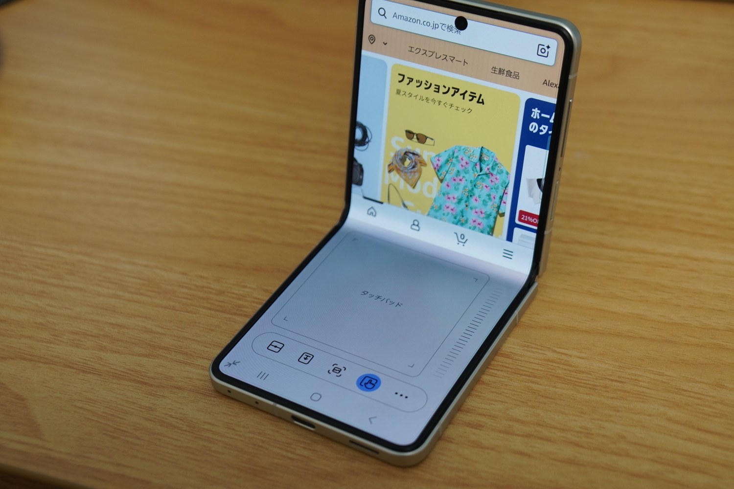 Galaxy Z Flip8を半開きにしてブラウザを開いたところ。上半分にページ、下半分にタッチパッドが表示される。