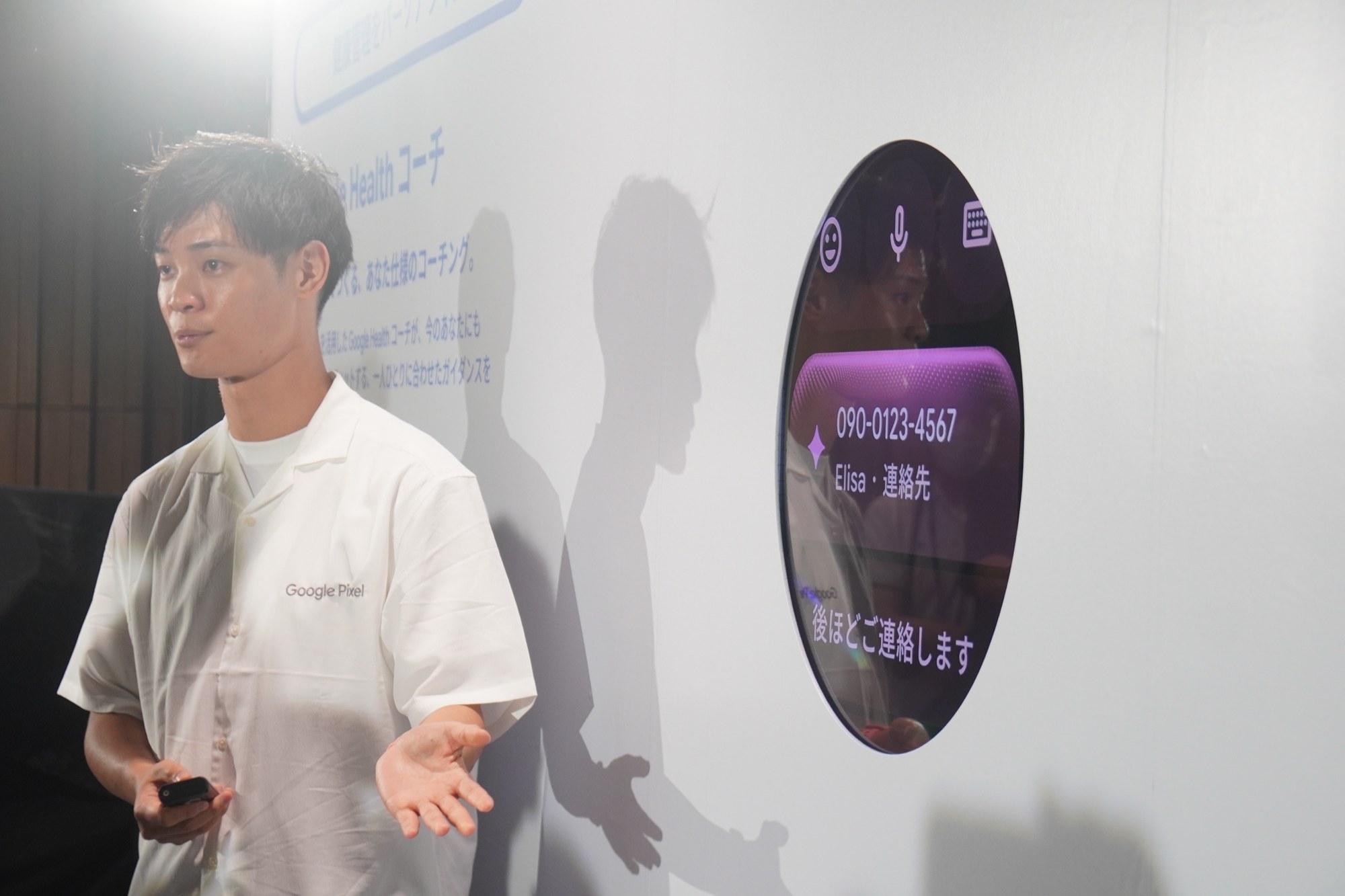 丸い表示パネルに電話番号と「後ほどご連絡します」が表示され、担当者がプロアクティブアシストを説明している