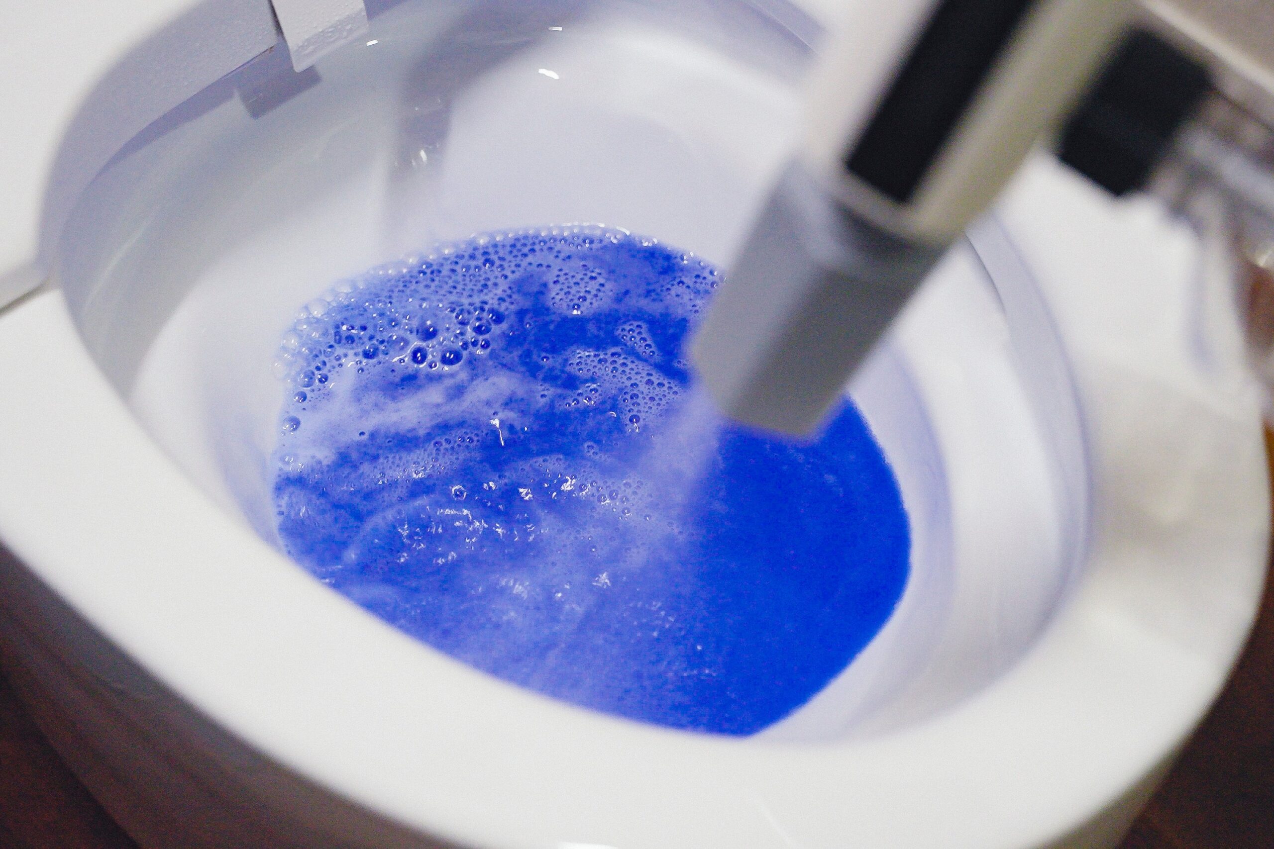 MIRABLE AQUABLAST MINIの泡ボトルを使い、便器を泡で洗浄している様子