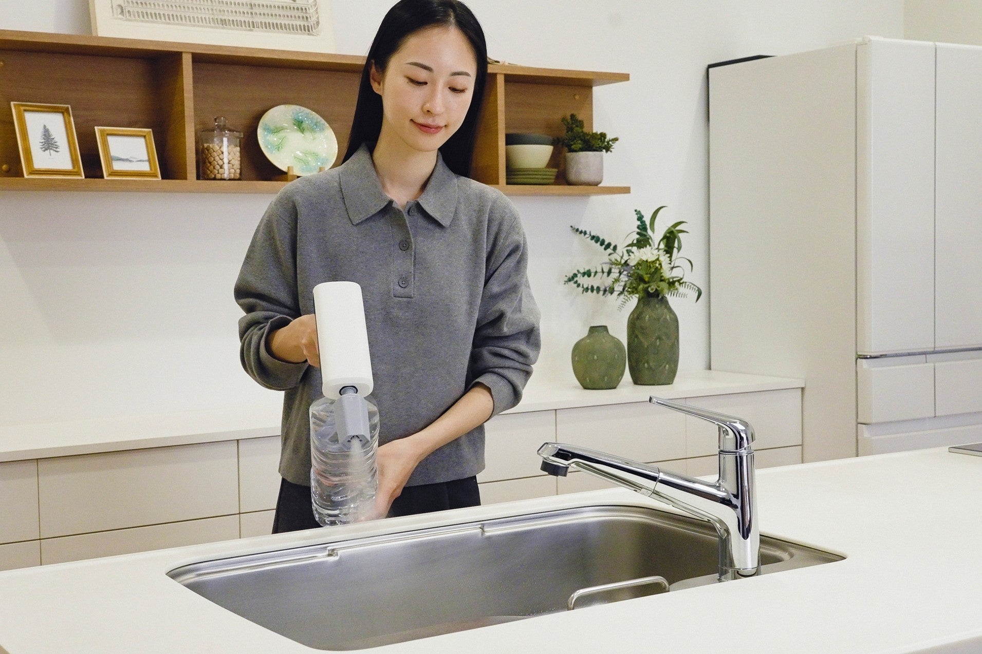 キッチンのシンク前でMIRABLE AQUABLAST MINIを使う様子。最大45℃の温水に対応する