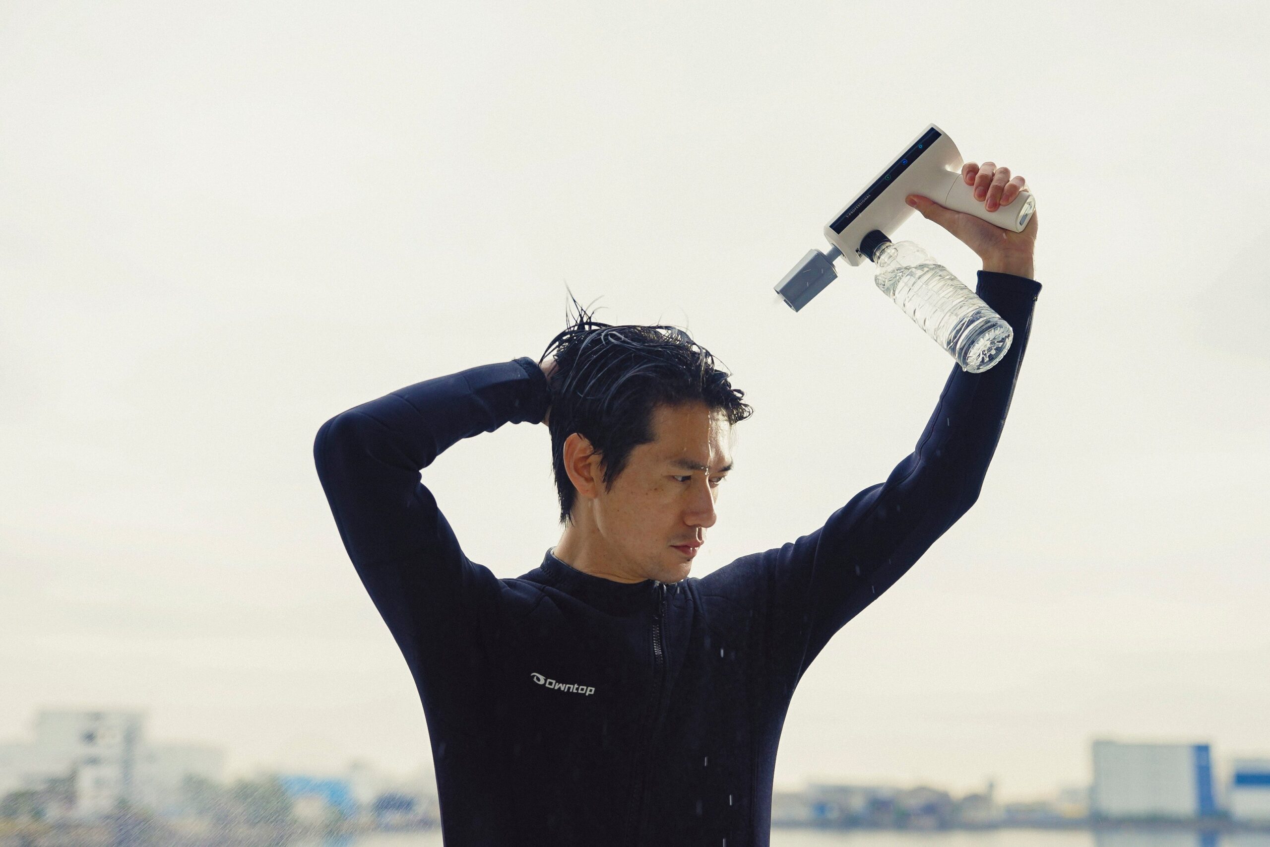 屋外でMIRABLE AQUABLAST MINIを頭上に構え、水を浴びている様子。緊急時の簡易シャワーにも使える