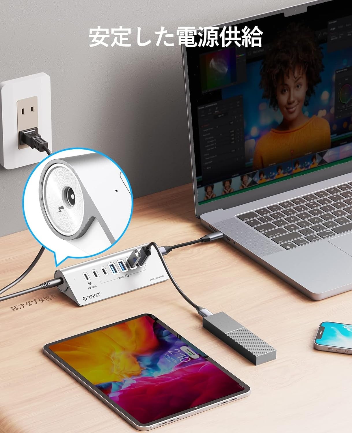 ORICOの7ポートUSB 3.2ハブにACアダプタをつなぎ、ノートパソコン・タブレット・外付けSSDを同時に接続したデスクの様子