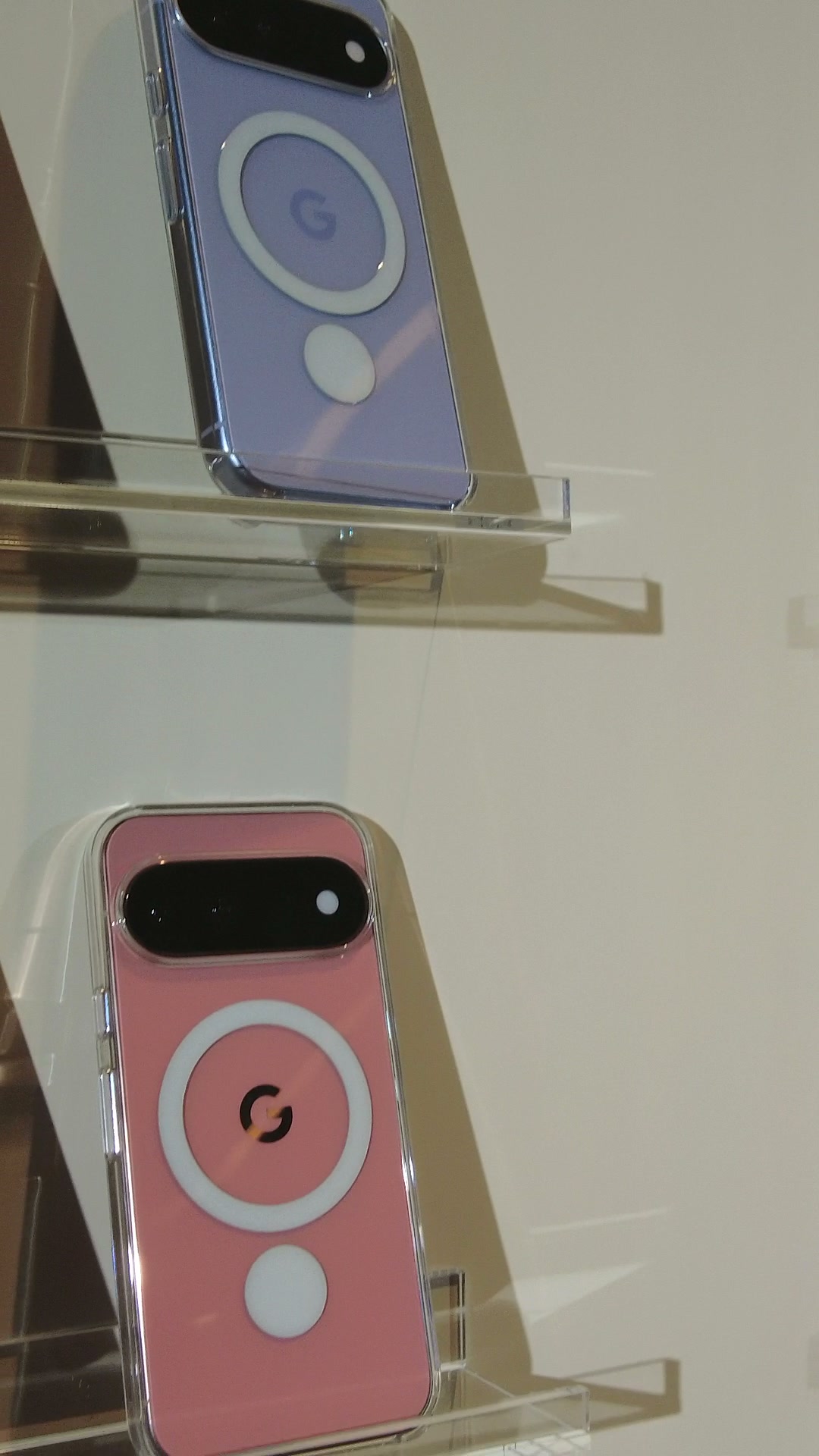 透明なクリアケースを着けた紫とピンクの Google Pixel 11 が展示台に並び、ケース越しに背面の Pixelsnap のリングが透けて見えている