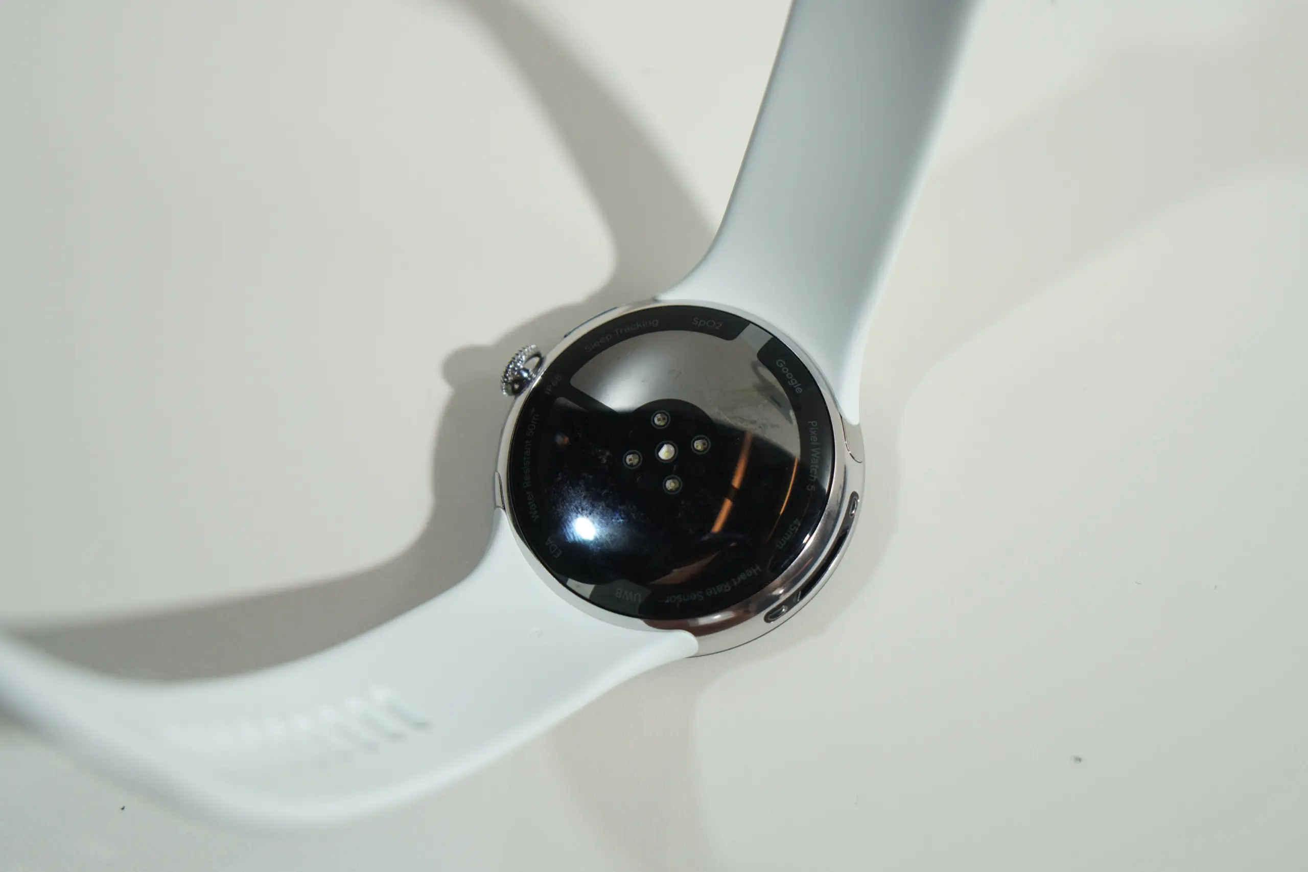 白いバンドを付けた Pixel Watch 5 の裏面。円形のセンサー部が見える