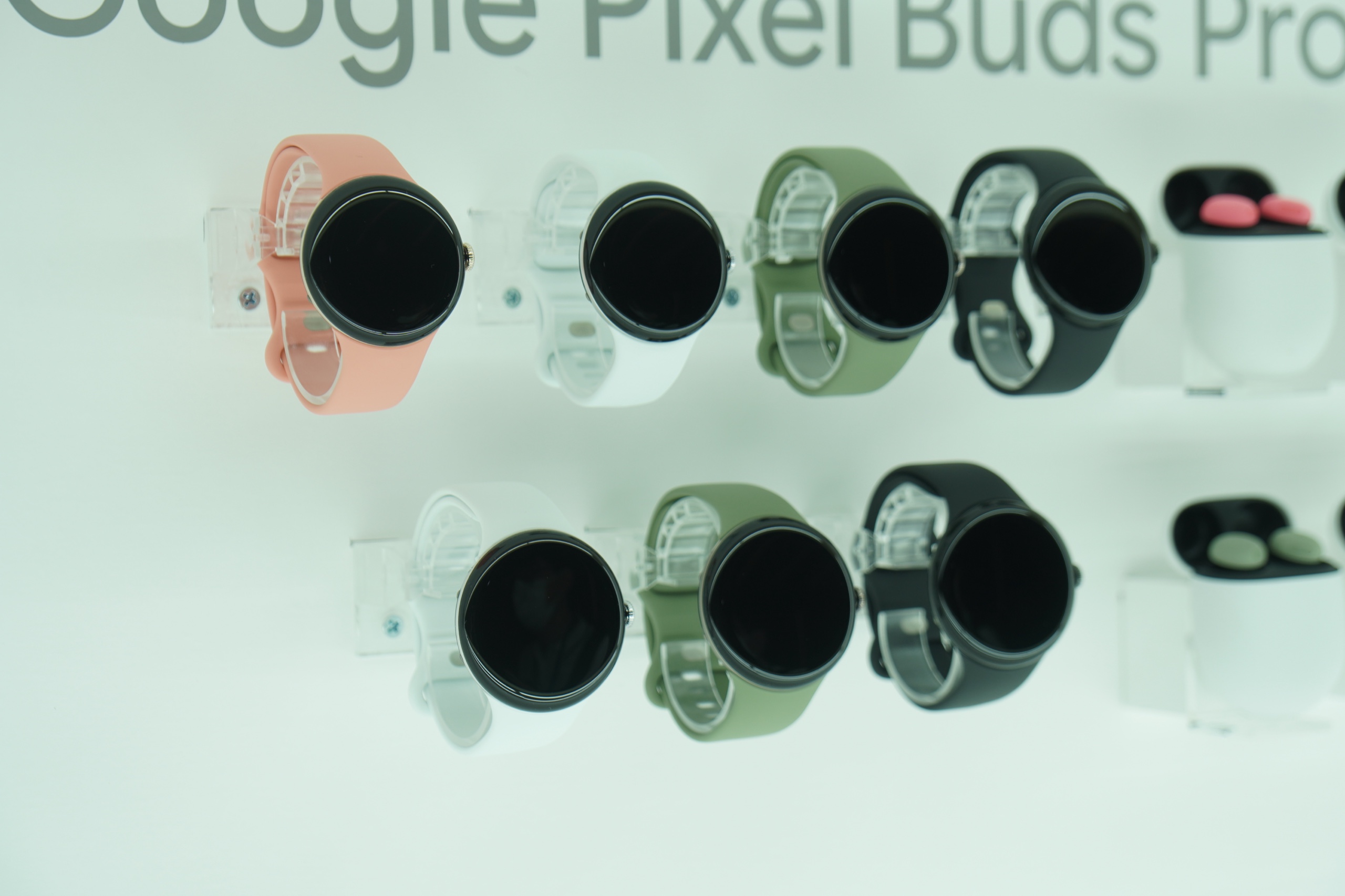コーラル、白、緑、黒のバンドを付けた Pixel Watch 5 が並んだ実機展示