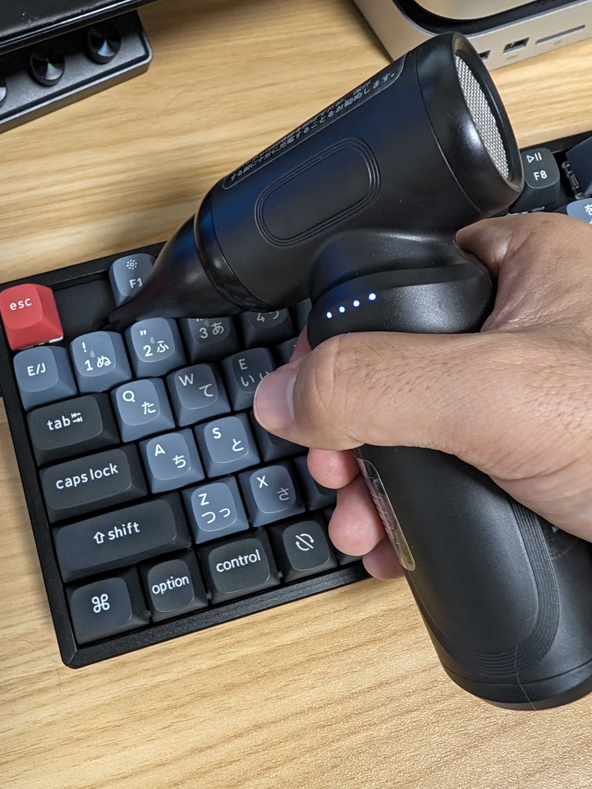 Ciniffo エアダスター W09 をキーボードに向けて構え、キーの隙間に風を送っているところ