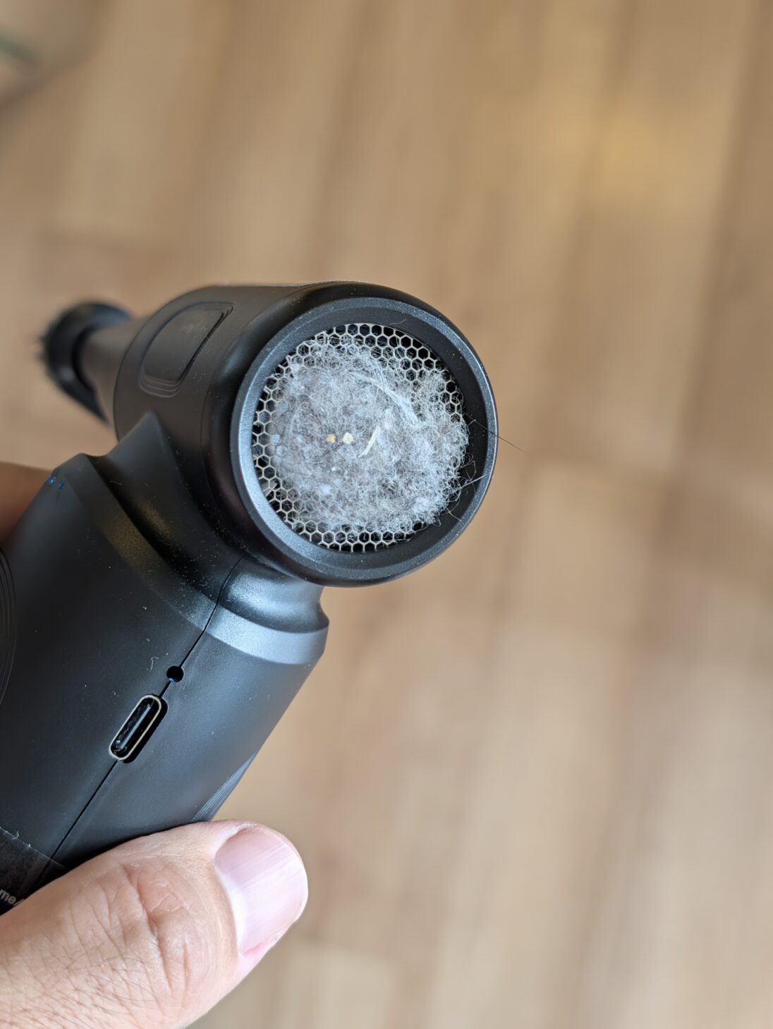 Ciniffo エアダスター W09 の裏側にある吸気口。ハニカム状のメッシュ全体に灰色の綿ボコリが層になって張り付き、髪の毛が外まで伸びて絡んでいる