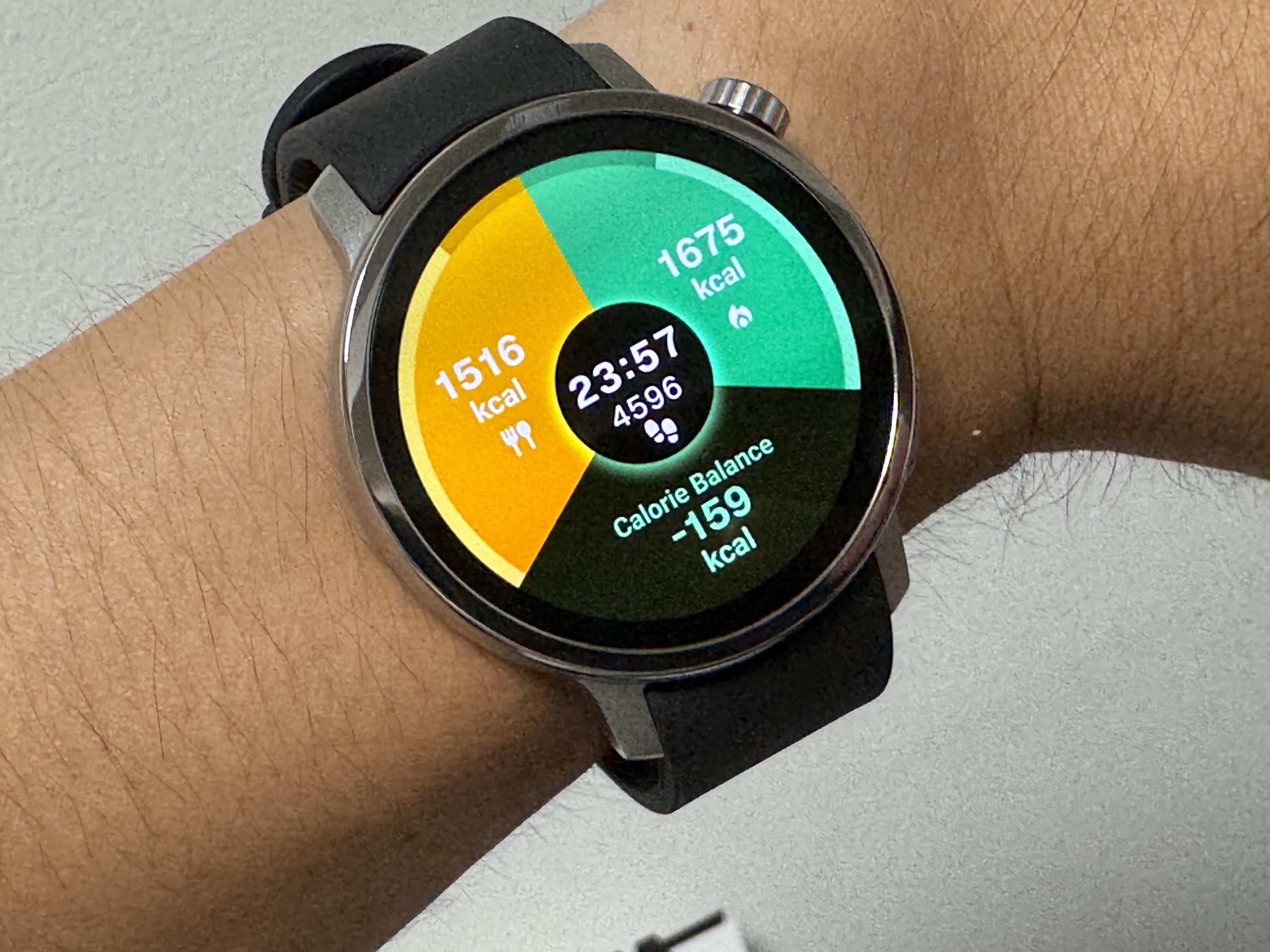 からだメイト Watchのカロリー収支ウォッチフェイス。23時57分時点で摂取1,516kcal・消費1,675kcal、歩数4,596歩、収支はマイナス159kcal