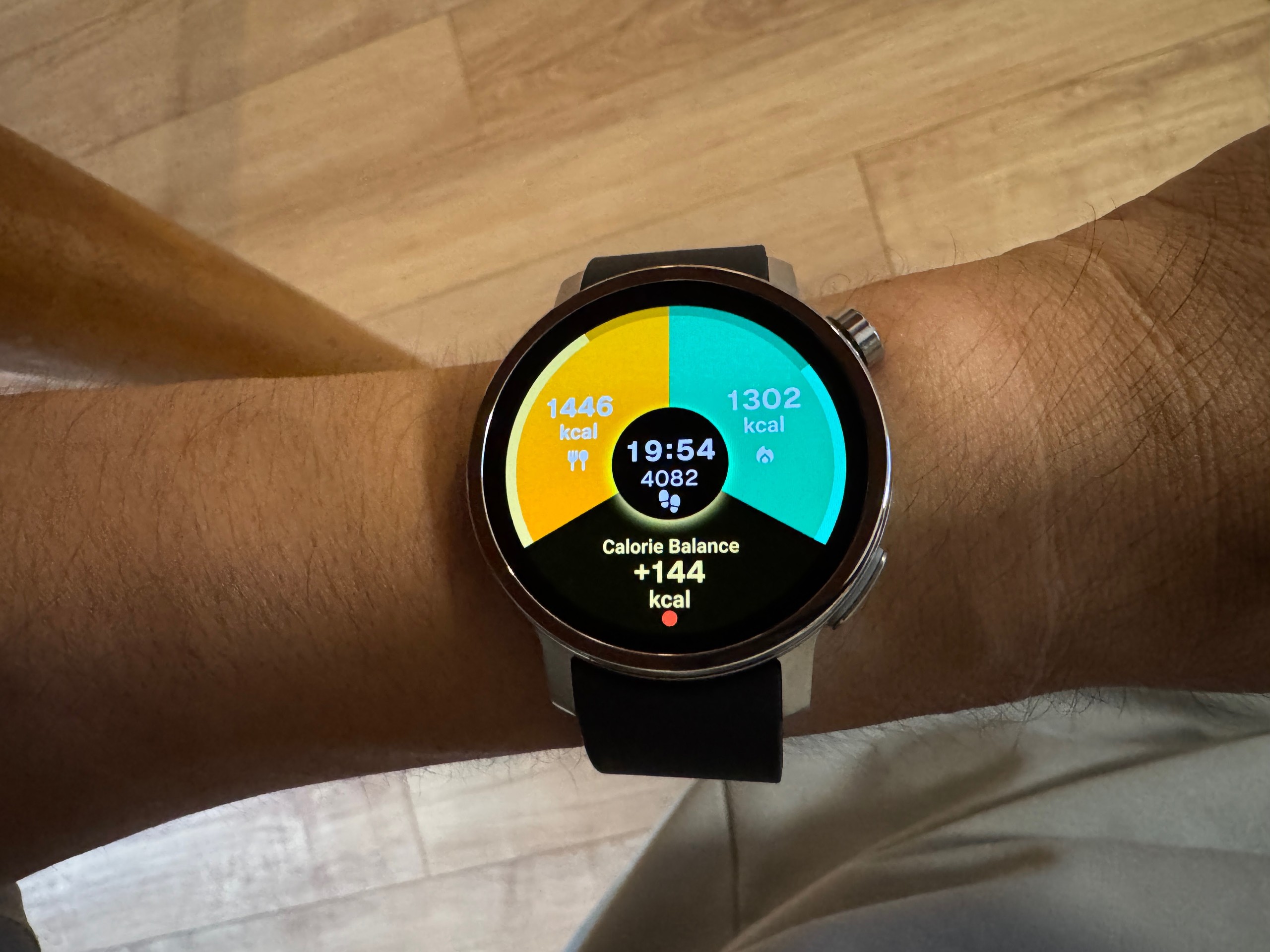 からだメイト Watchのカロリー収支ウォッチフェイス。19時54分時点で摂取1,446kcal・消費1,302kcal、収支はプラス144kcal
