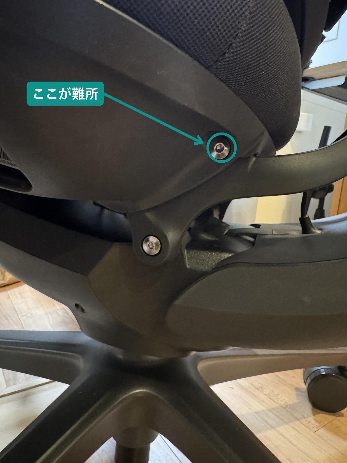 LiberNovo Omni Pro の座面ベース裏側。組み立て工程4で入りづらかったネジの位置をテーマ緑の丸で示した写真。中央のネジではなく、座面ベースの縁にある1本が難所