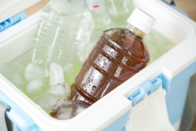 氷と冷えたペットボトル飲料が入ったクーラーボックス。こまめな水分・塩分補給のイメージ