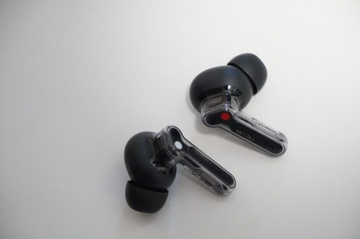 Nothing Ear (3a) のイヤホン左右。シースルーのステムに右を示す赤い丸と左を示す白い丸が入る