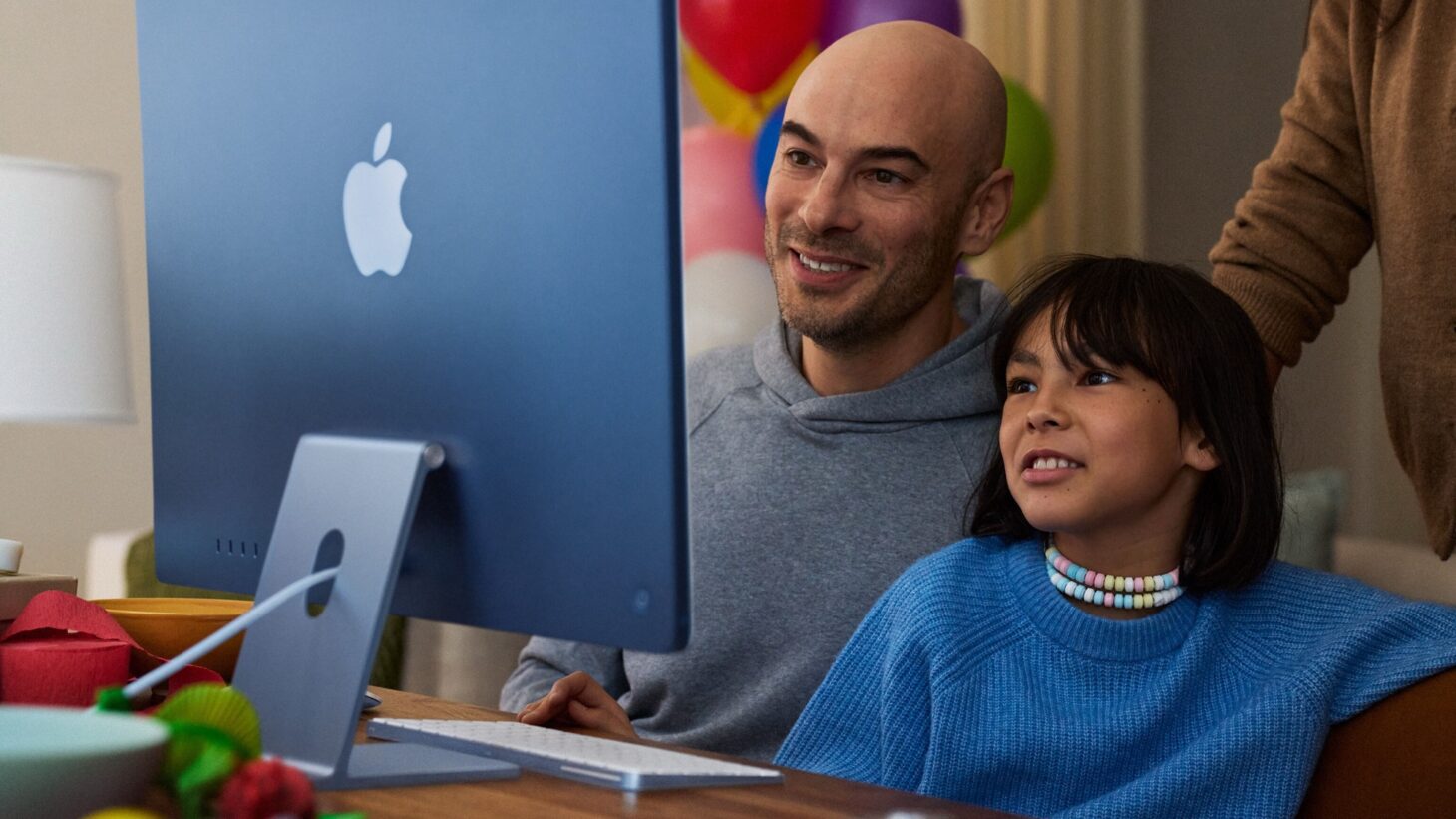 iMacの画面を父親と子どもが一緒にのぞき込んでいる様子。Appleと米国小児科学会(AAP)が公開した家族向けガイドのイメージ写真