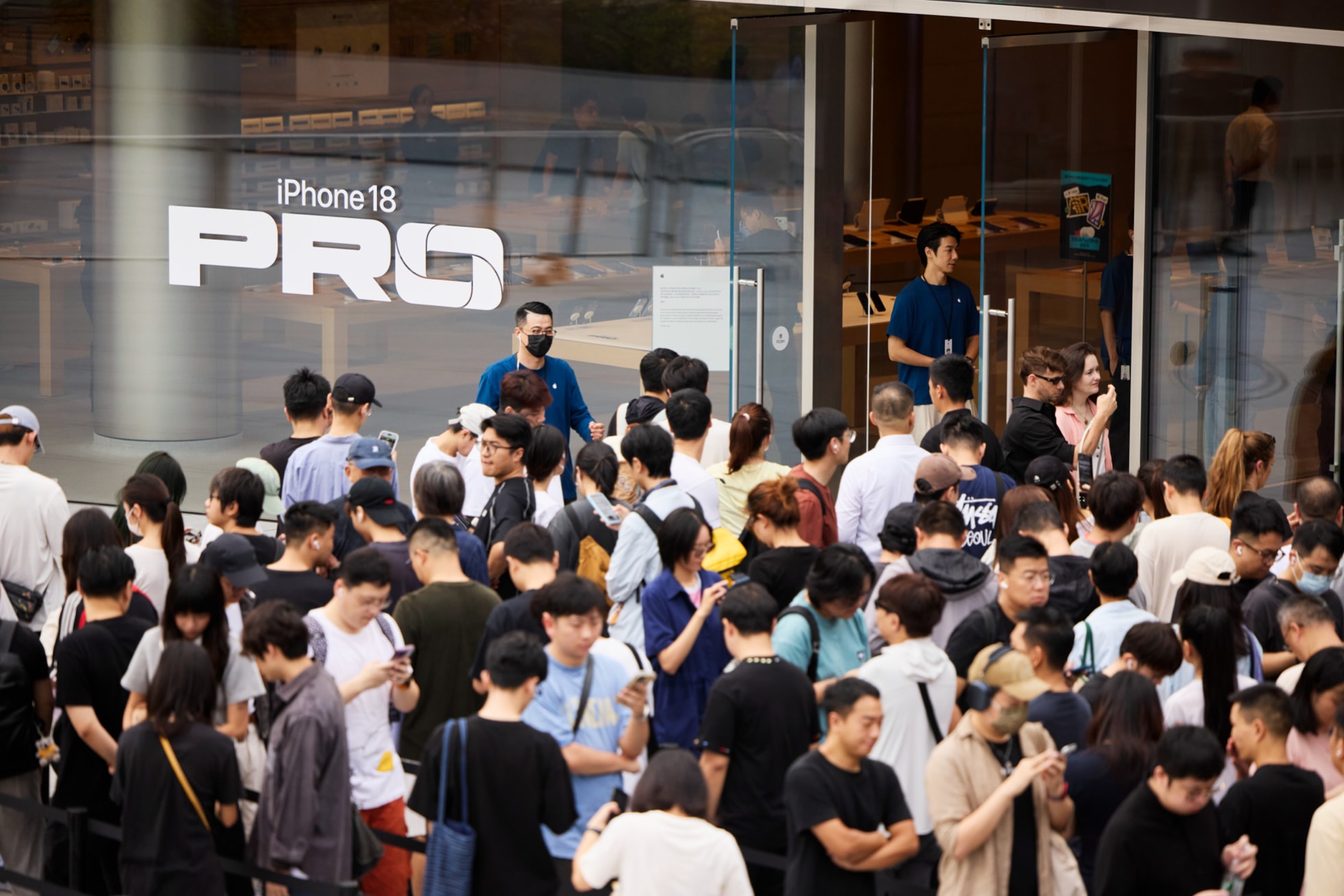 Apple Jing’anの外に立って開店を待つ来店客と、その様子を見守るAppleのチームメンバー。