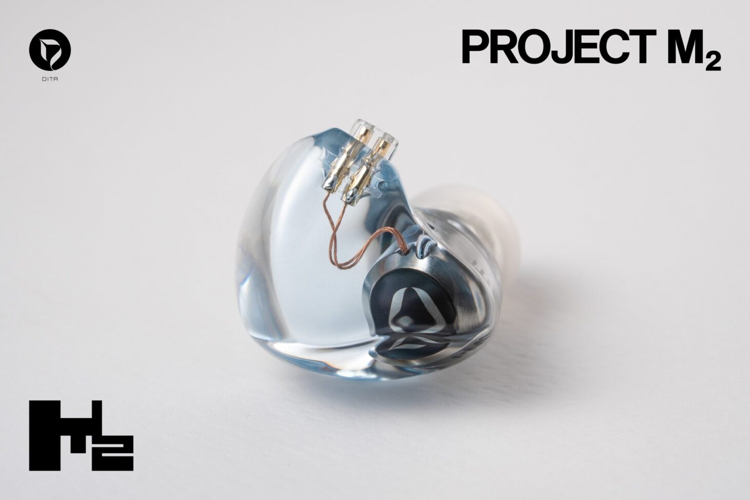 DITAの有線イヤホン「Project M2」。アイシーブルーの透明な樹脂筐体にステンレス製の音響チャンバーが見える