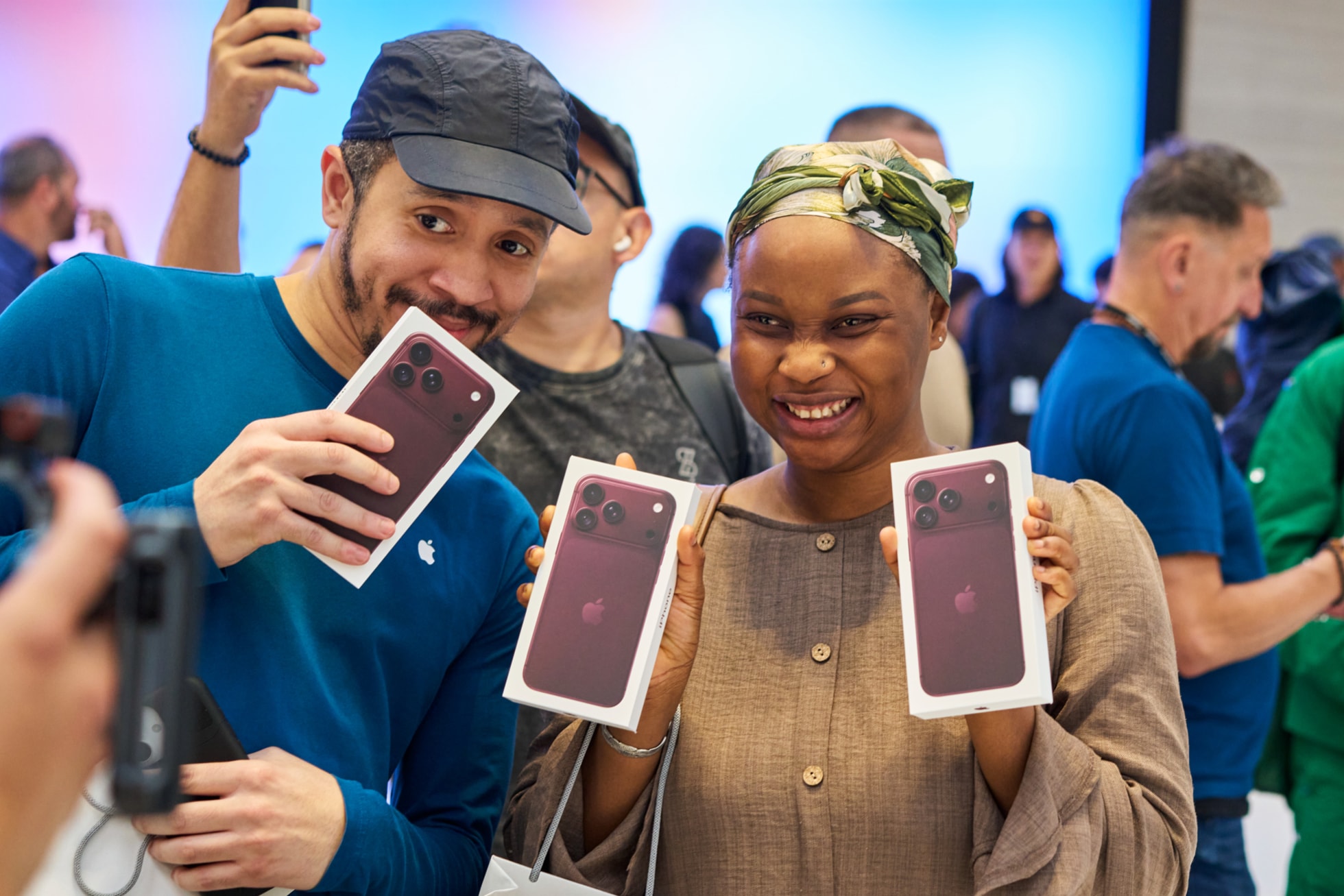 Apple Fifth Avenueで購入したiPhone 18 Proを掲げている来店客とAppleのチームメンバー。