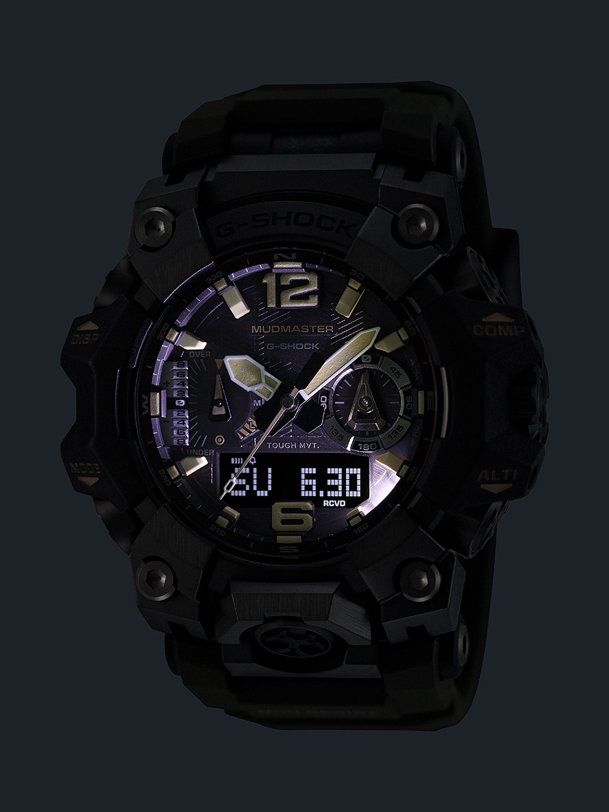 暗い場所でライトを点灯したG-SHOCK MUDMASTER GWG-B1000-1A3JF。文字板と液晶表示が照らされている