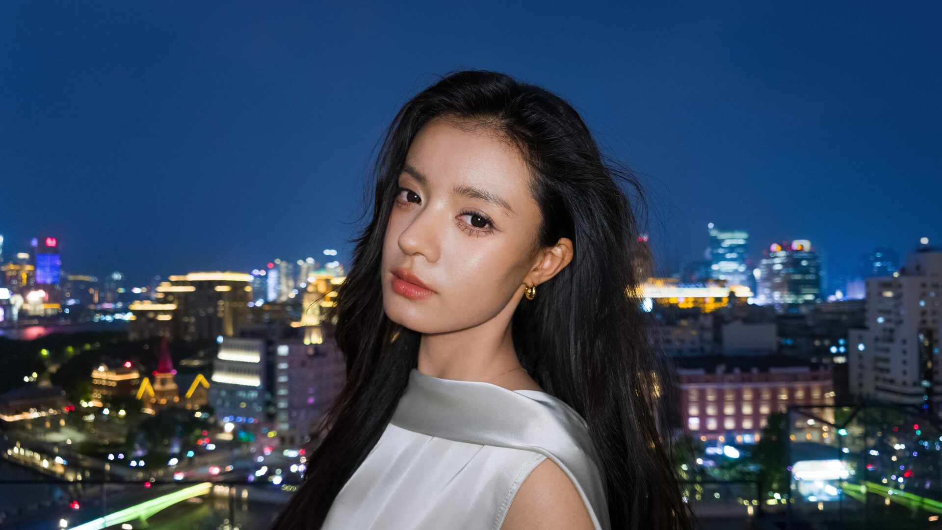 Luna Proで撮影した夜景を背景にした人物のポートレート。1インチ8Kセンサーによる低照度性能を示す作例