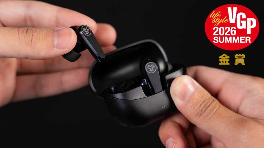 充電ケースからJLabのワイヤレスイヤホン Go Pods ANC を取り出しているところ。VGP2026 SUMMER金賞のバッジが添えられている