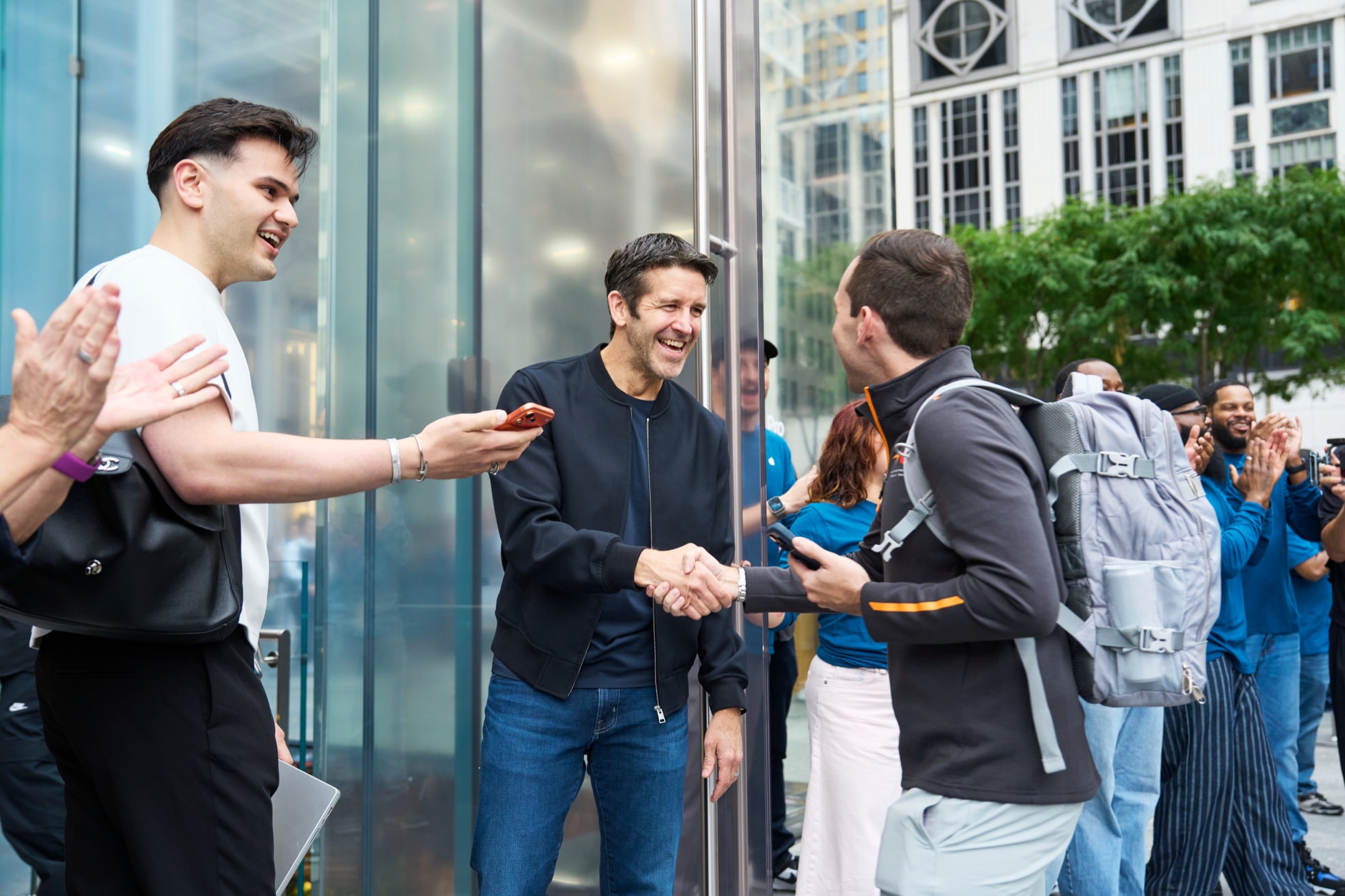 Apple Fifth Avenueで来店客と握手して迎えるAppleのジョン・ターナス。