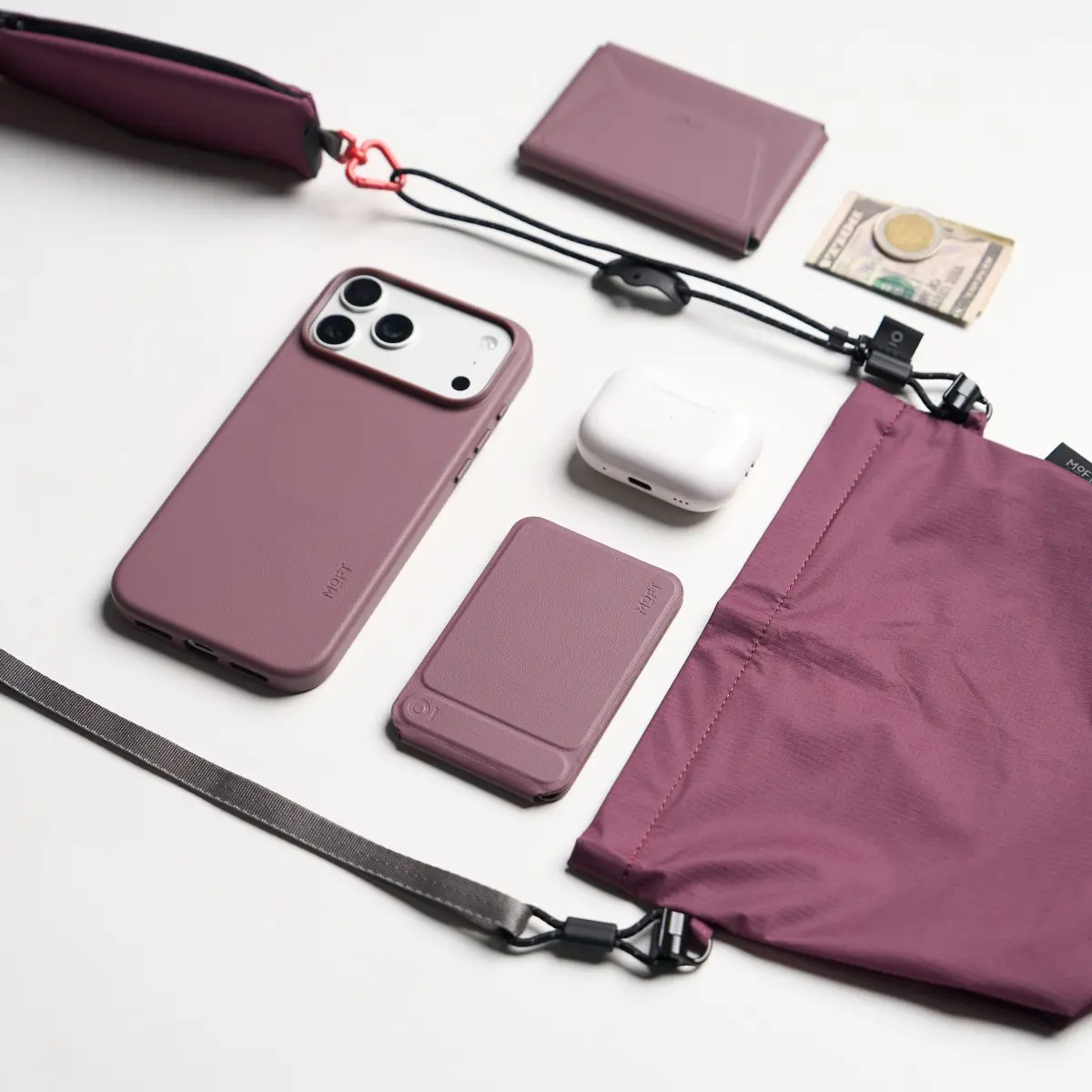 MOFT パッカブルマルチストラップと、iPhone、カードケース、AirPods、折りたたみポーチを並べたところ。ストラップに小物を集約できる