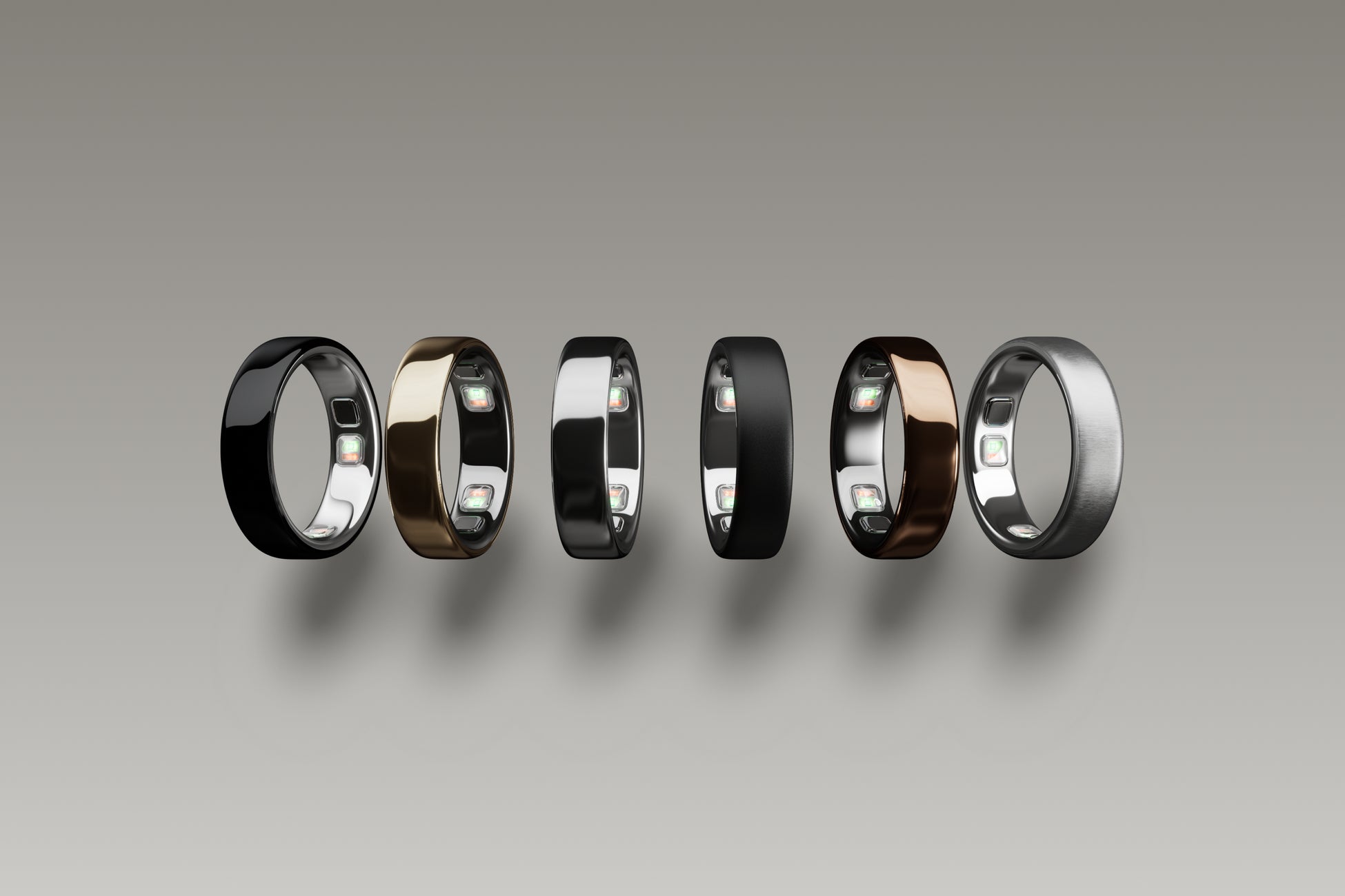 Oura Ring 5のカラーバリエーション6色が横一列に並んでいる。左からブラック、ゴールド、シルバー、ステルス、ディープローズ、ブラッシュドシルバーで、内側のセンサーが見えている
