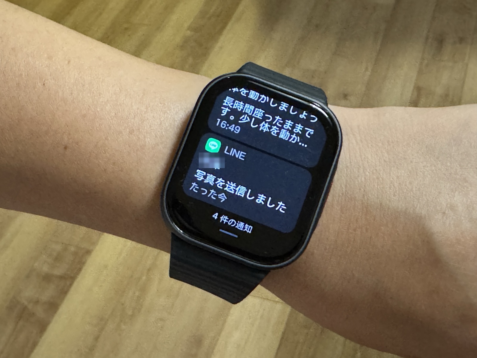 REDMI Watch 6 Liteの画面に、座りすぎを知らせる通知とLINEの通知が並んで表示されている。送信者名はぼかし処理